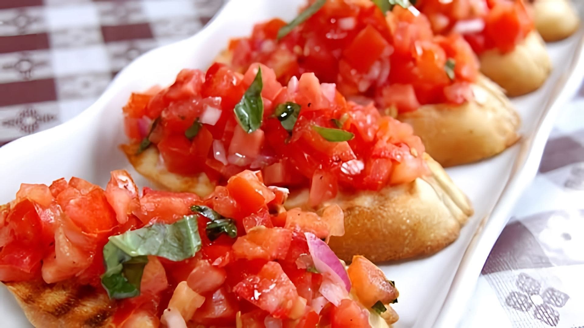 В этом видео демонстрируется рецепт итальянской закуски брускетта с помидорами