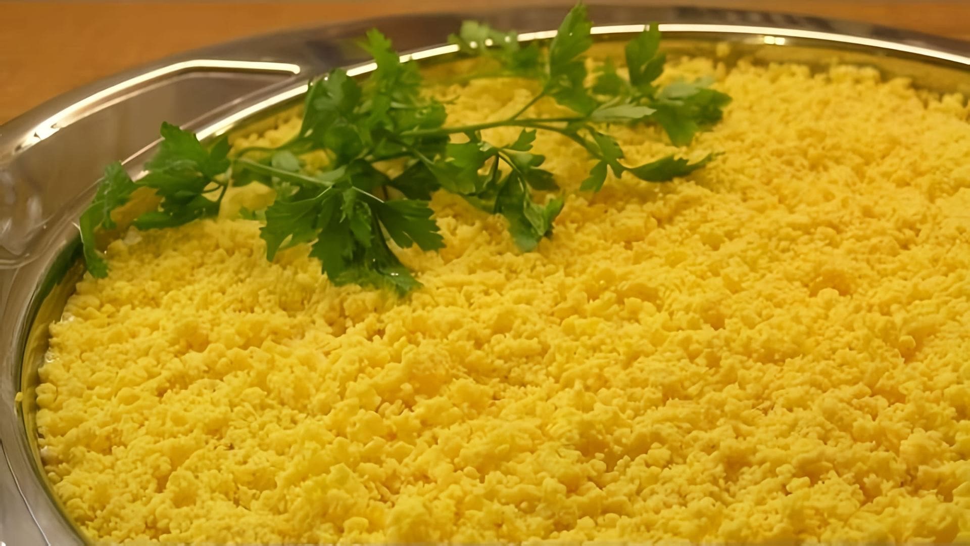 В данном видео демонстрируется процесс приготовления салата Мимоза, который является одним из основных блюд на праздничном столе