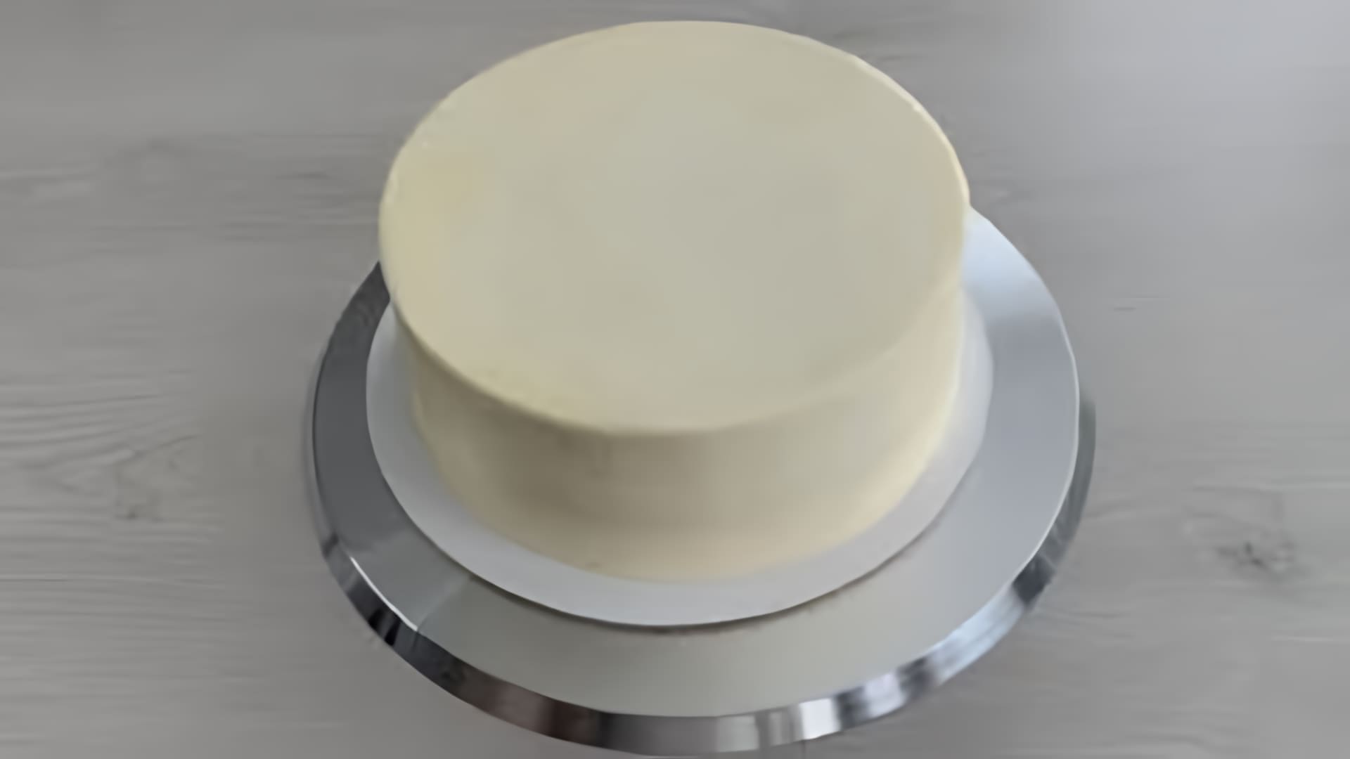 В этом видео демонстрируется процесс приготовления крем-чиза на масле для выравнивания торта