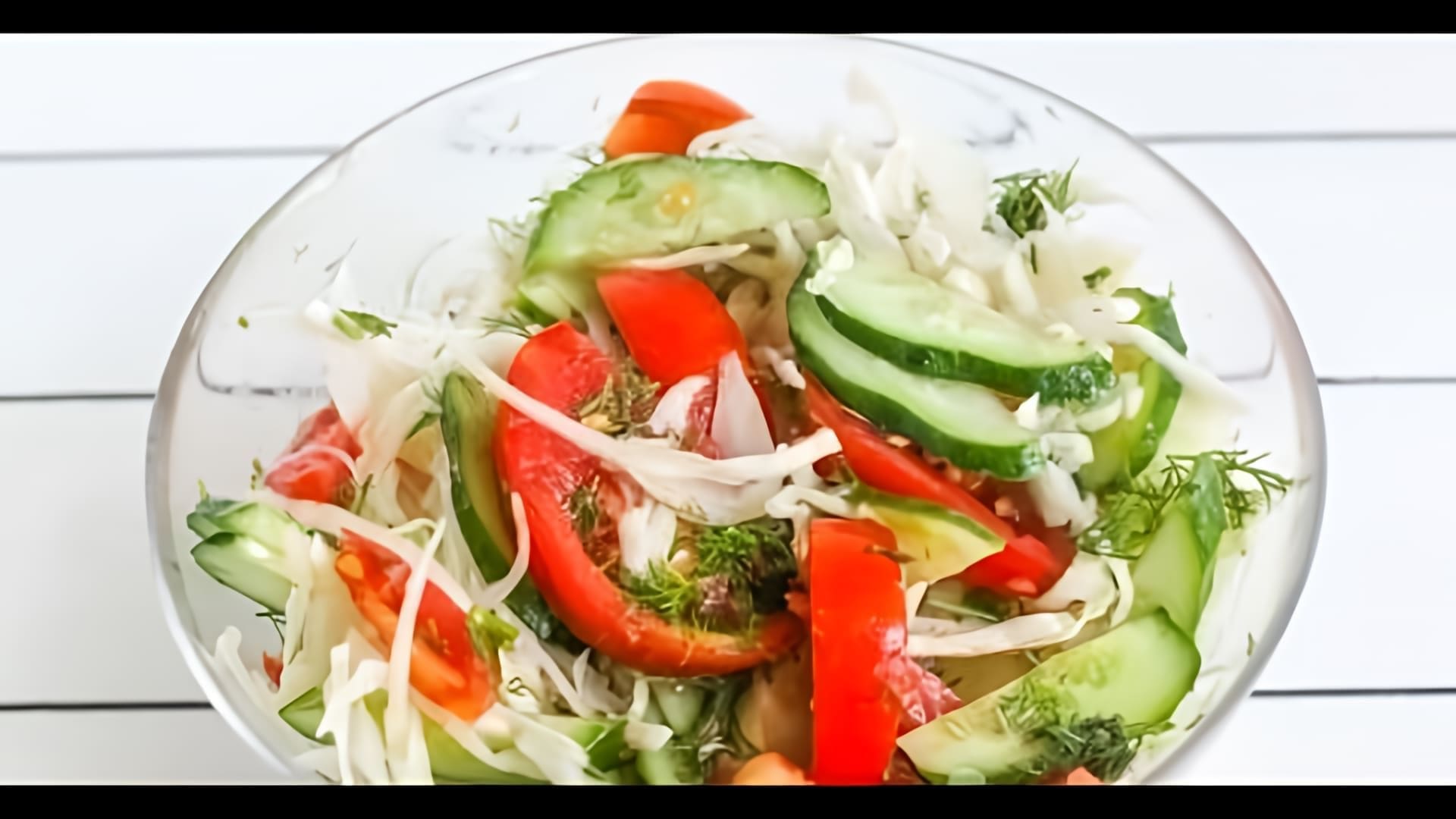 В этом видео демонстрируется процесс приготовления салата из свежей капусты, огурцов и помидоров