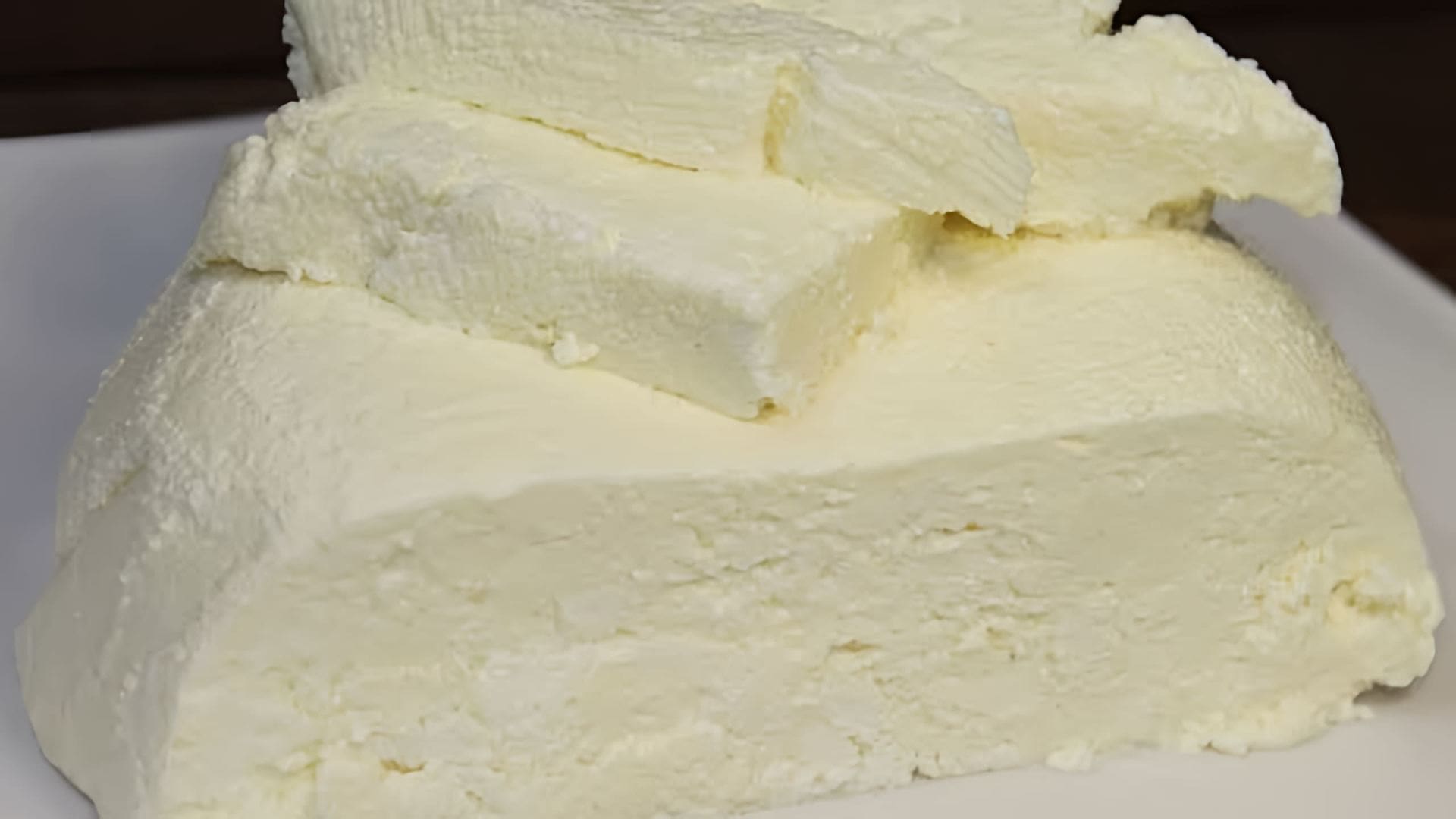 В этом видео демонстрируется процесс приготовления домашнего сыра из молока и сметаны