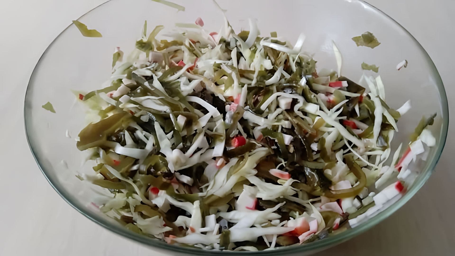 В этом видео демонстрируется процесс приготовления салата с морской капустой