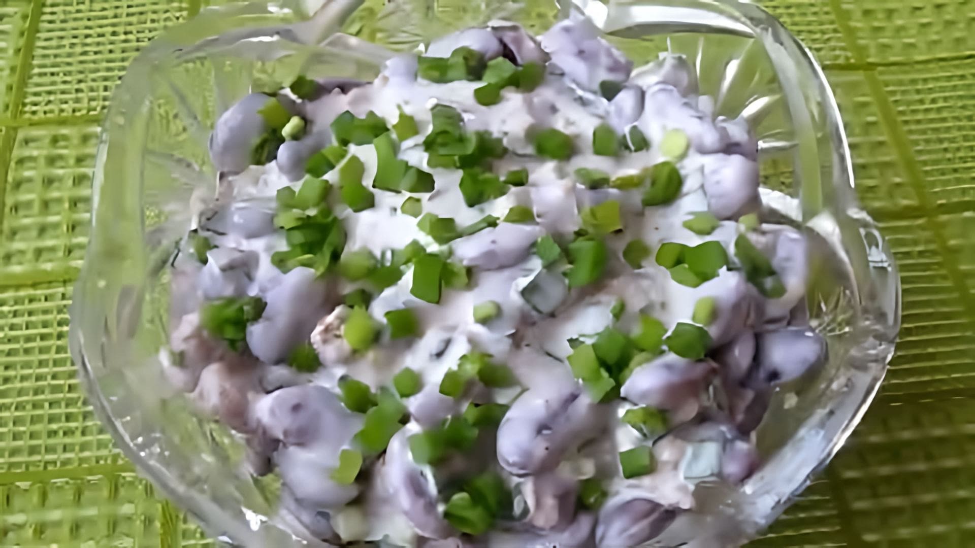 В этом видео демонстрируется процесс приготовления салата из красной фасоли с кириешками