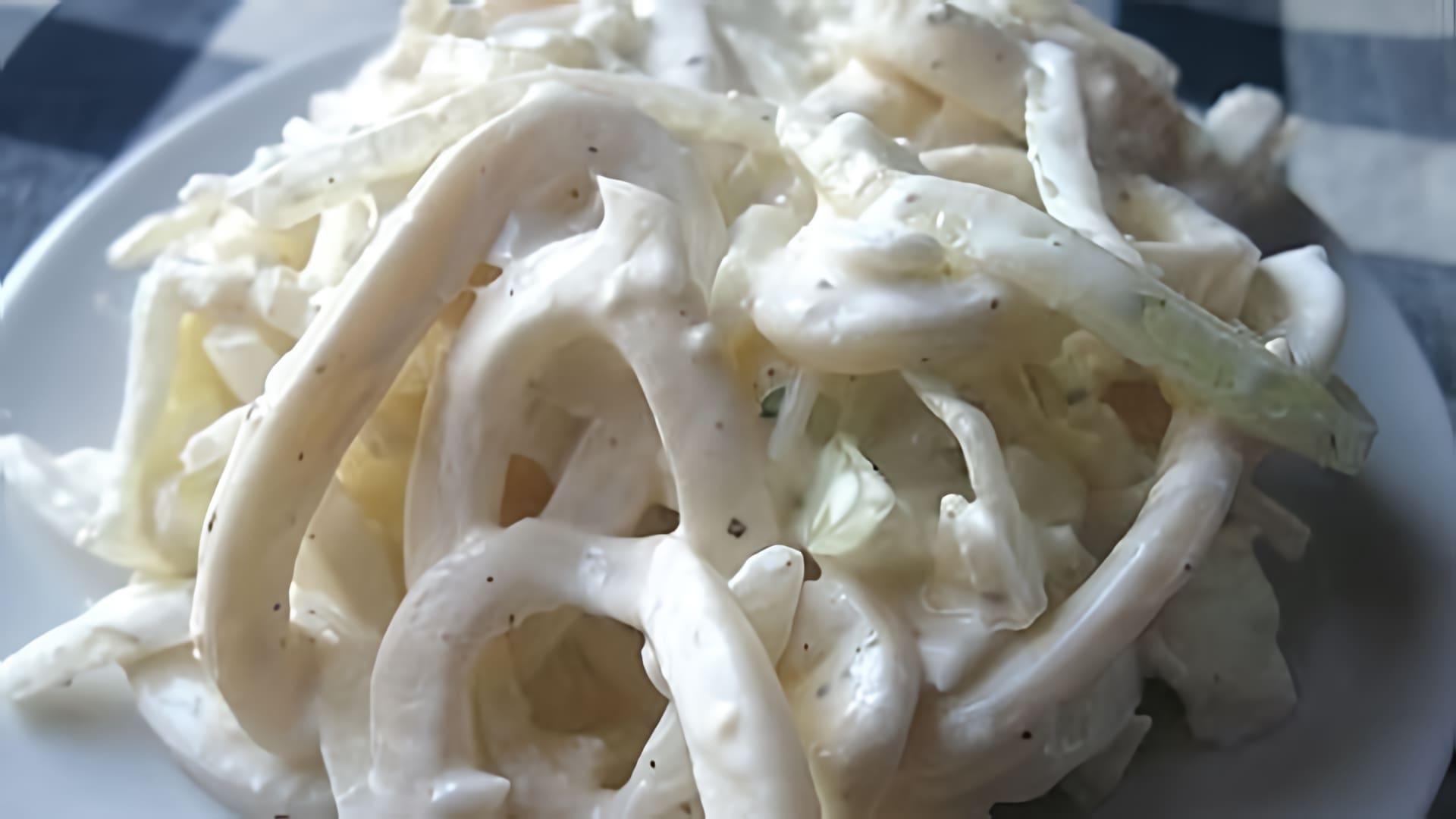 В этом видео демонстрируется процесс приготовления салата из кальмаров с луком и яйцом