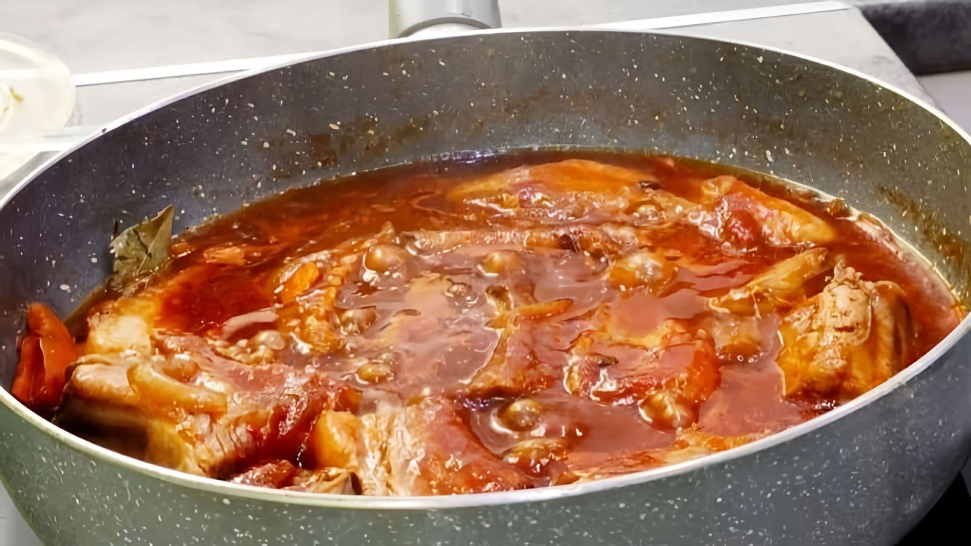В этом видео демонстрируется процесс приготовления свиных рёбрышек, тушеных в томатном соусе
