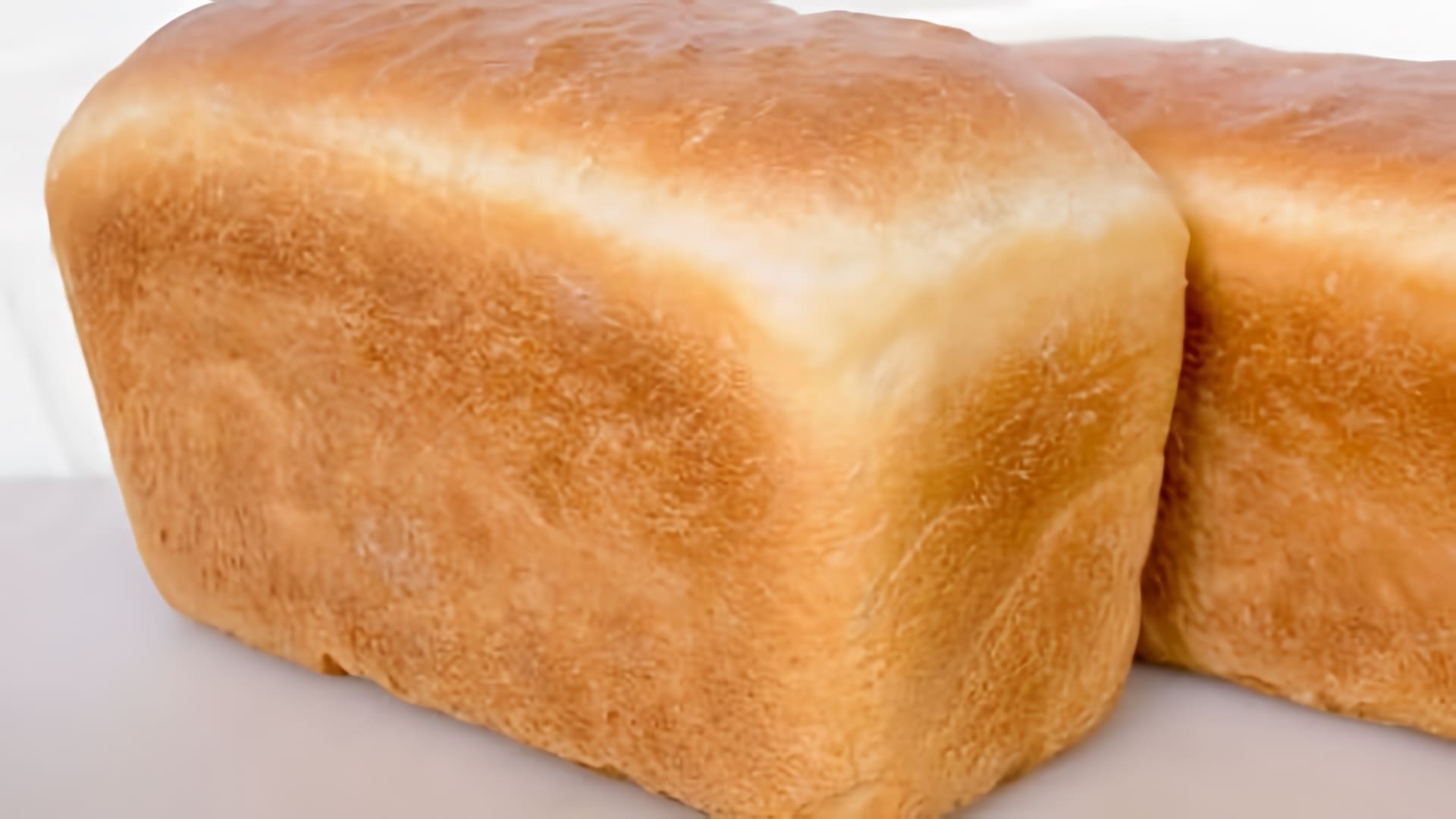 В данном видео демонстрируется процесс приготовления домашнего белого хлеба в духовке