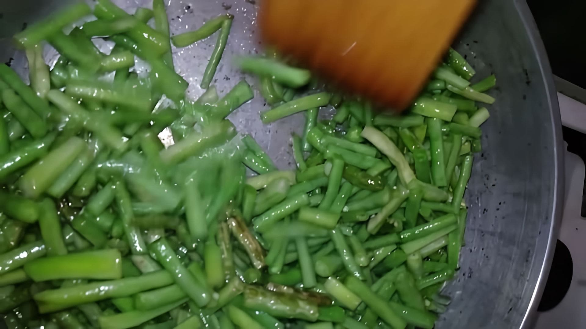 В этом видео демонстрируется процесс приготовления блюда из спаржевой фасоли сорта "вигна"