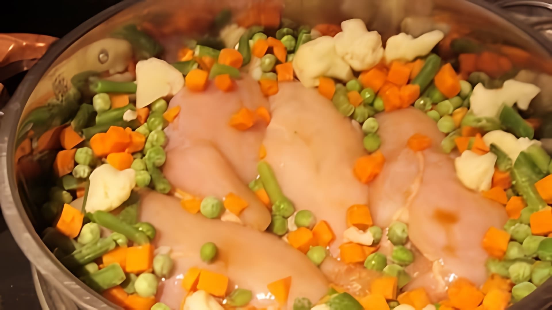 В этом видео демонстрируется процесс приготовления курицы с овощами в пароварке