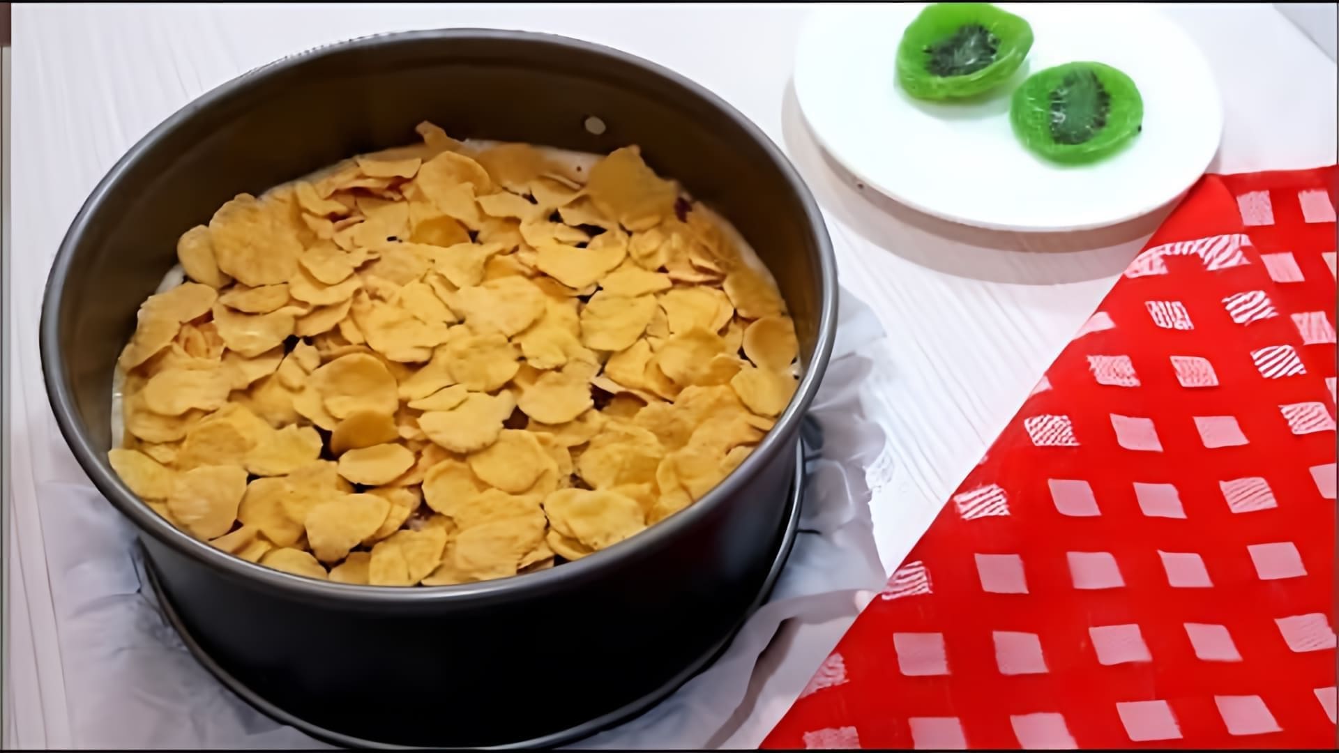 В этом видео демонстрируется рецепт приготовления бисквитного пирога с кукурузными хлопьями и сухофруктами