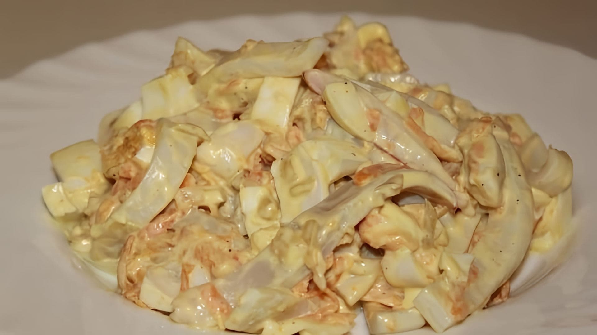 В этом видео демонстрируется процесс приготовления салата с кальмарами и яйцами