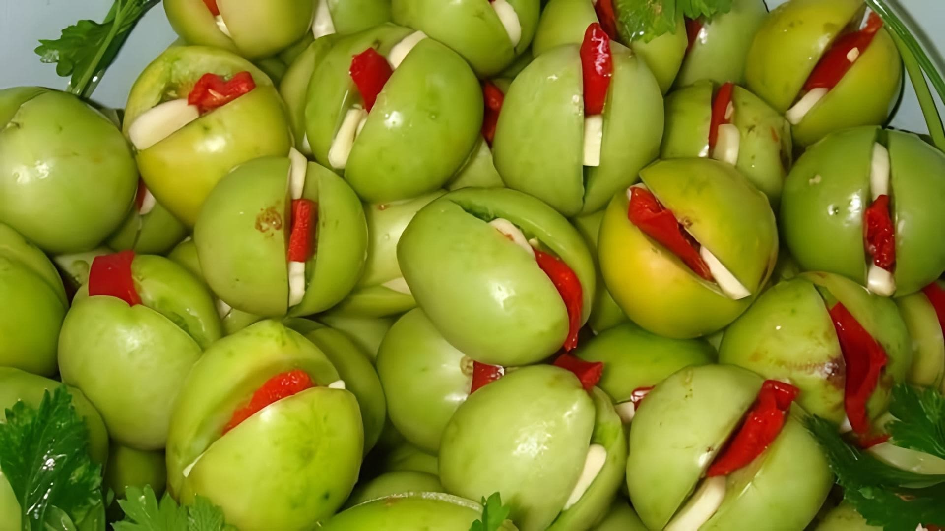 В этом видео-ролике показан процесс приготовления зеленых помидоров, фаршированных зеленью и чесноком