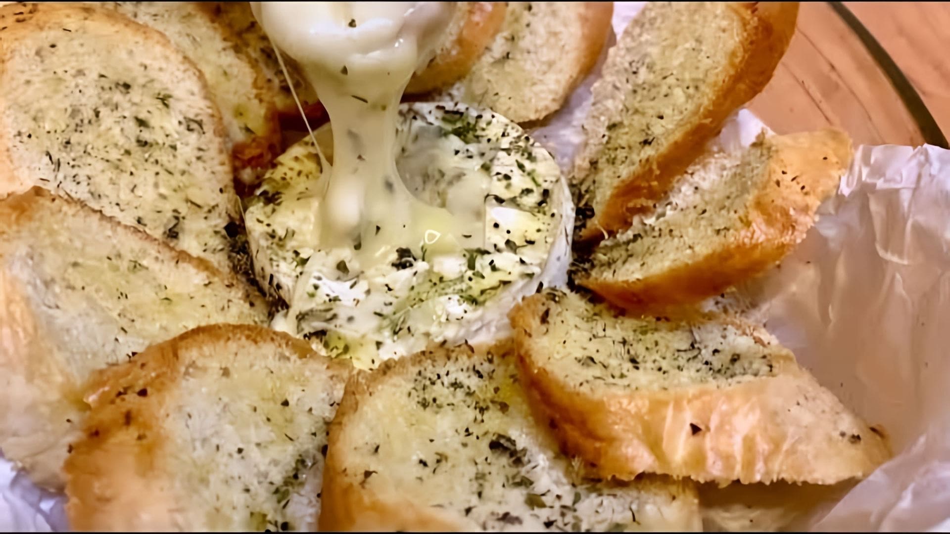 В этом видео демонстрируется рецепт приготовления запеченного сыра Камамбер в духовке с чесноком, ароматными травами и хрустящим багетом