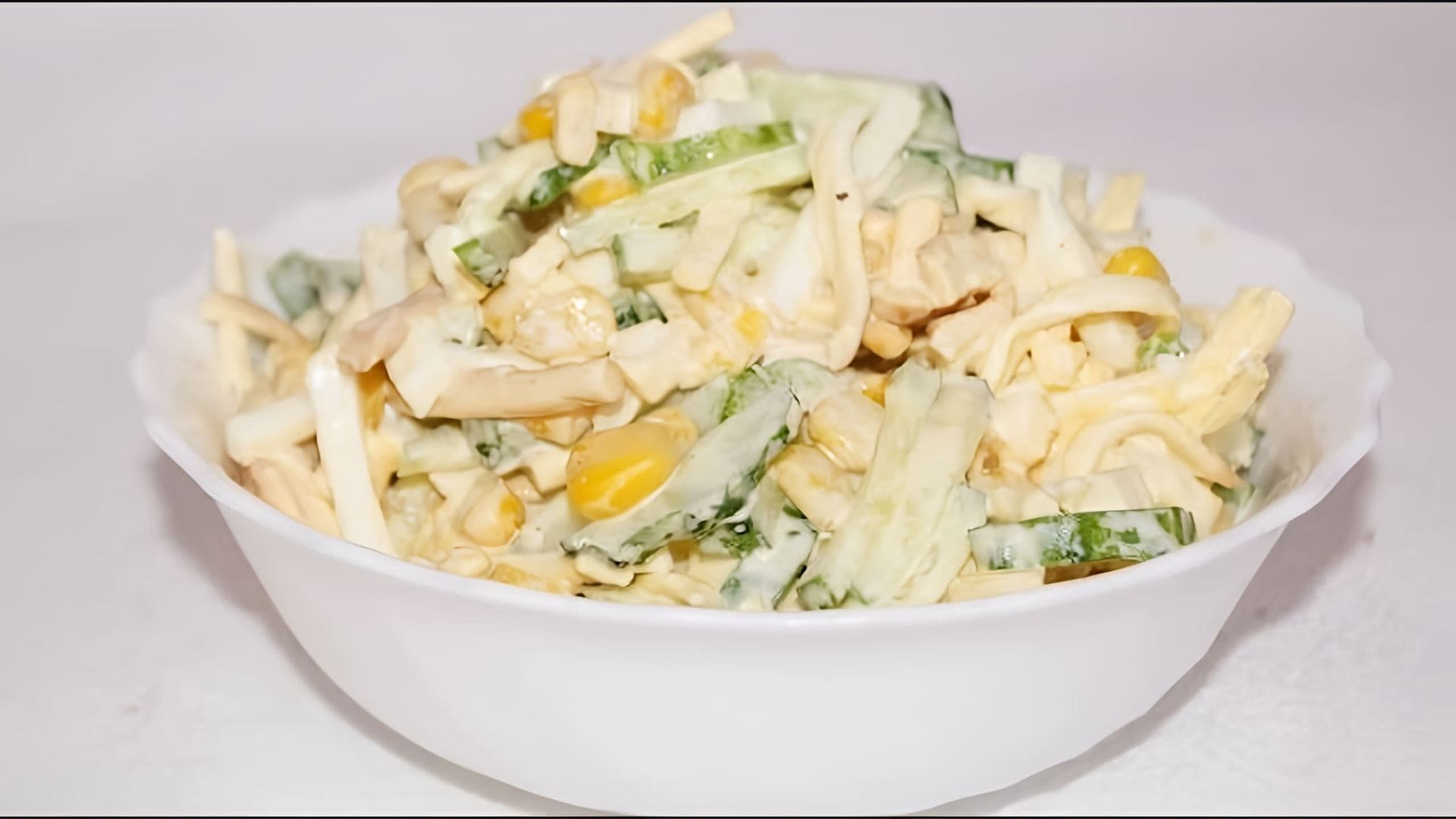 В этом видео демонстрируется процесс приготовления пикантного салата с сыром косичка