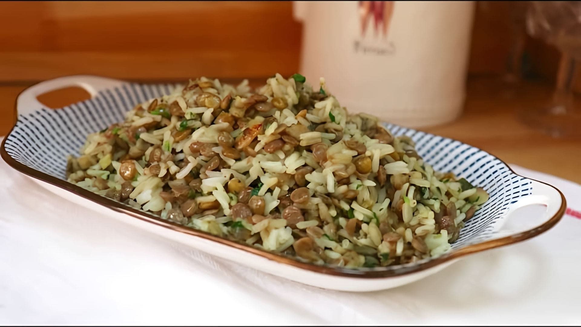 В этом видео демонстрируется процесс приготовления гарнира из риса с чечевицей