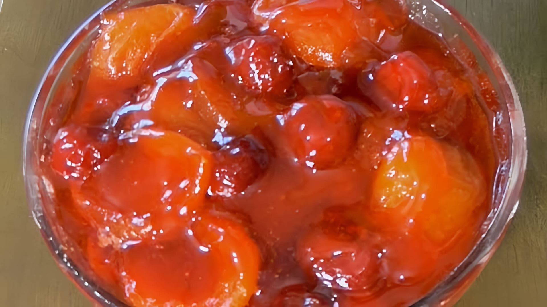 В этом видео демонстрируется процесс приготовления абрикосового варенья с вишнями