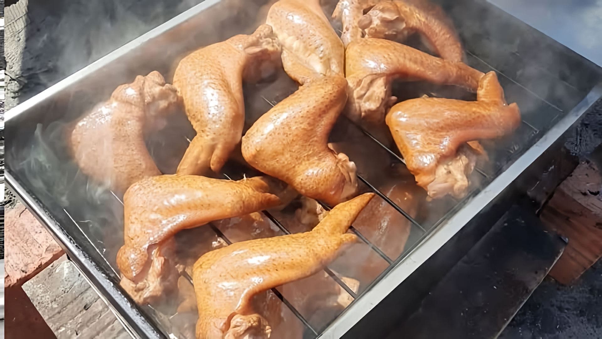 В этом видео демонстрируется процесс приготовления куриных крылышек горячего копчения в домашних условиях