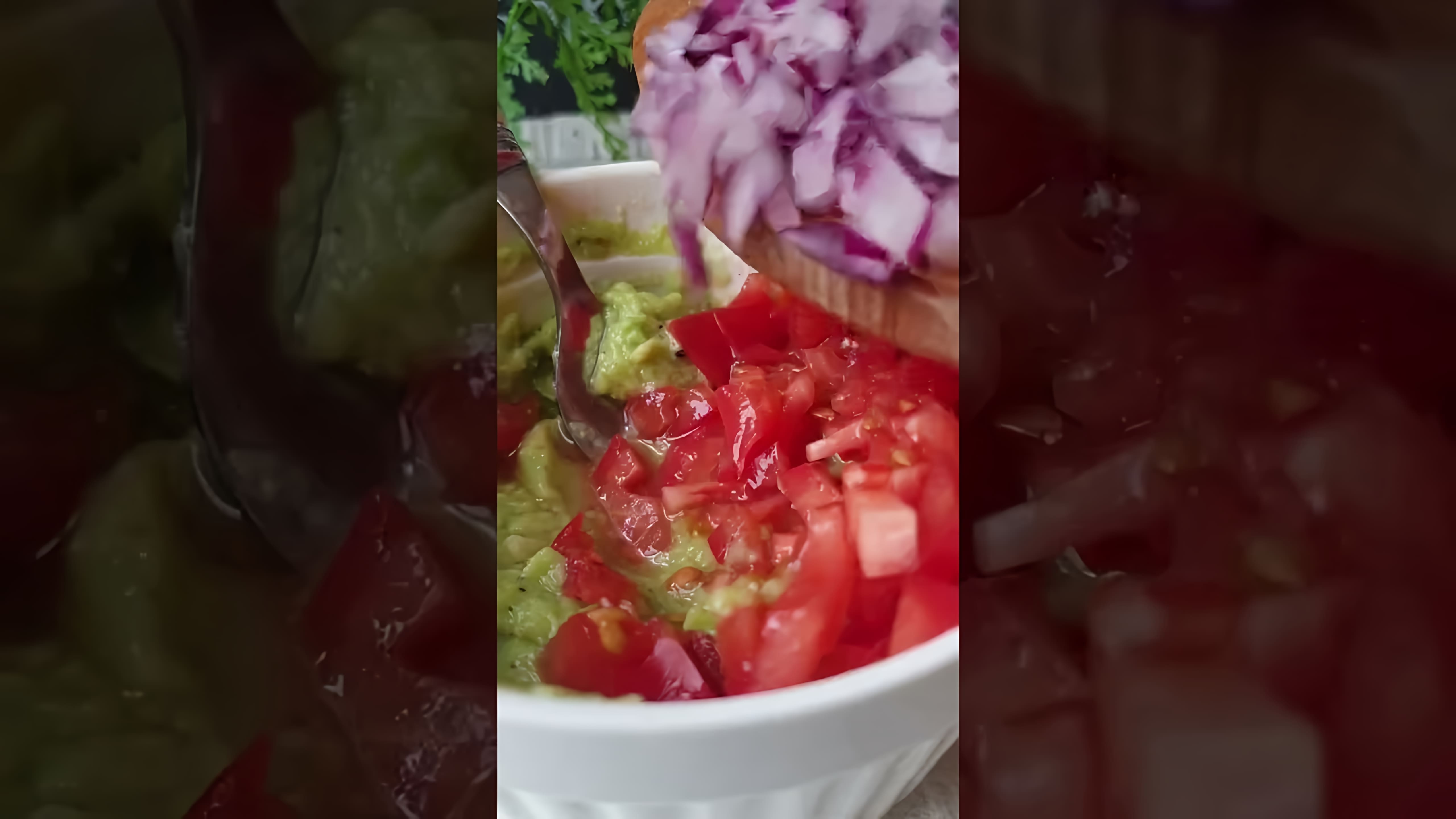 В этом видео демонстрируется рецепт приготовления соуса гуакамоле с томатами и красным луком