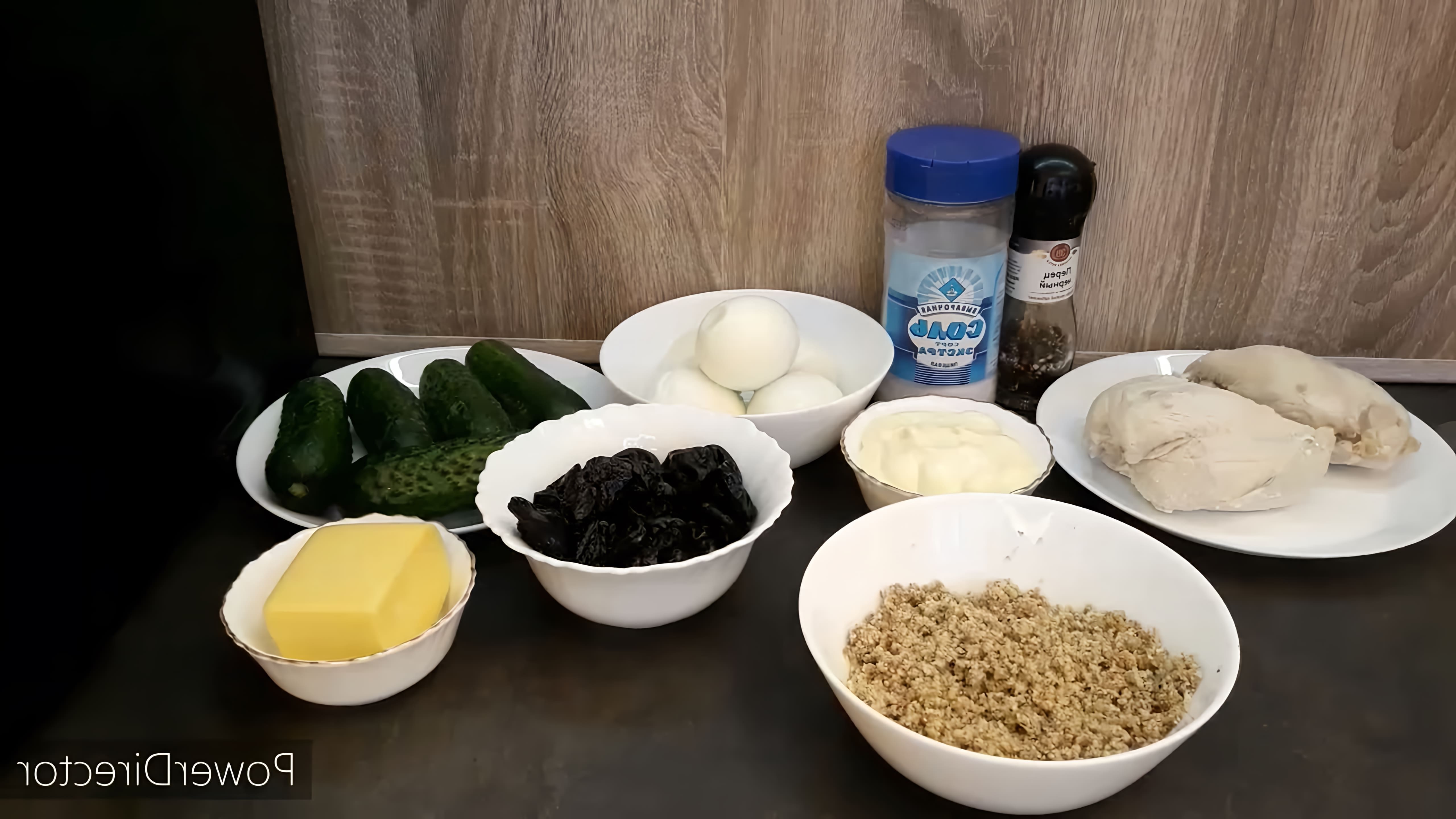 В этом видео демонстрируется процесс приготовления слоеного салата с курицей, черносливом, огурцом и яйцами