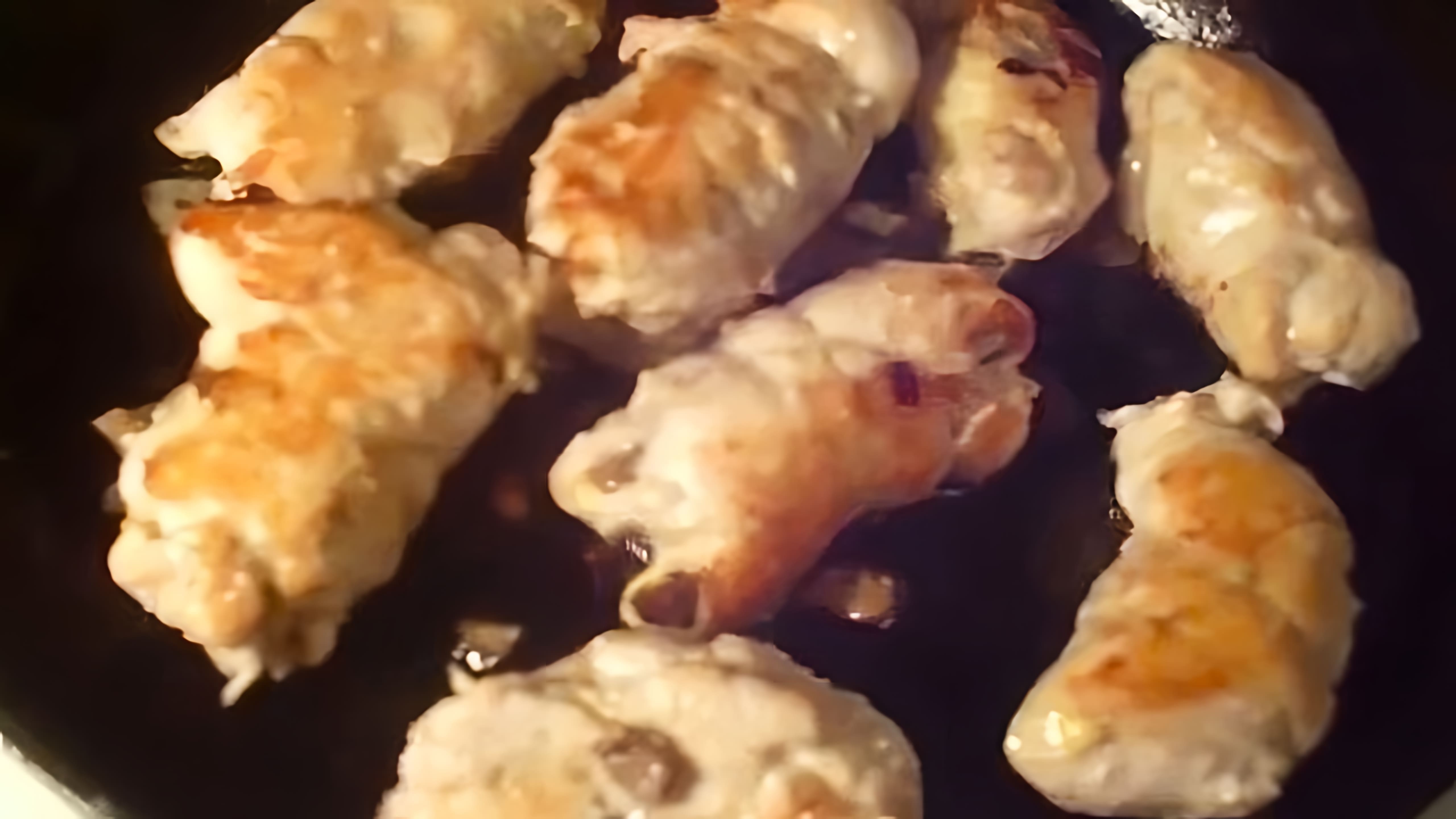 В этом видео демонстрируется процесс приготовления куриных рулетиков с грибами и сыром в сметанном соусе
