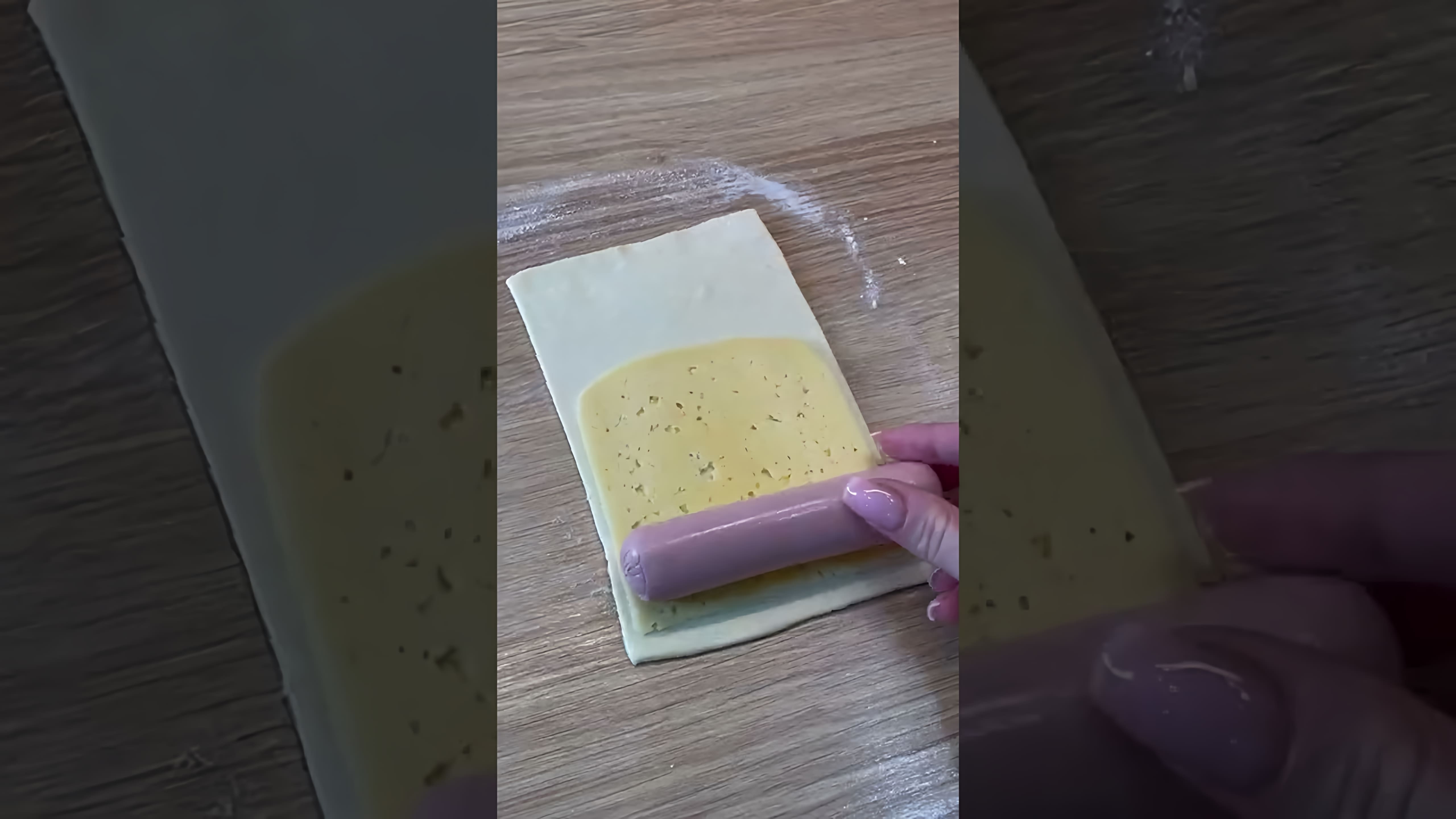 В этом видео демонстрируется рецепт приготовления сосисок в слоёном тесте