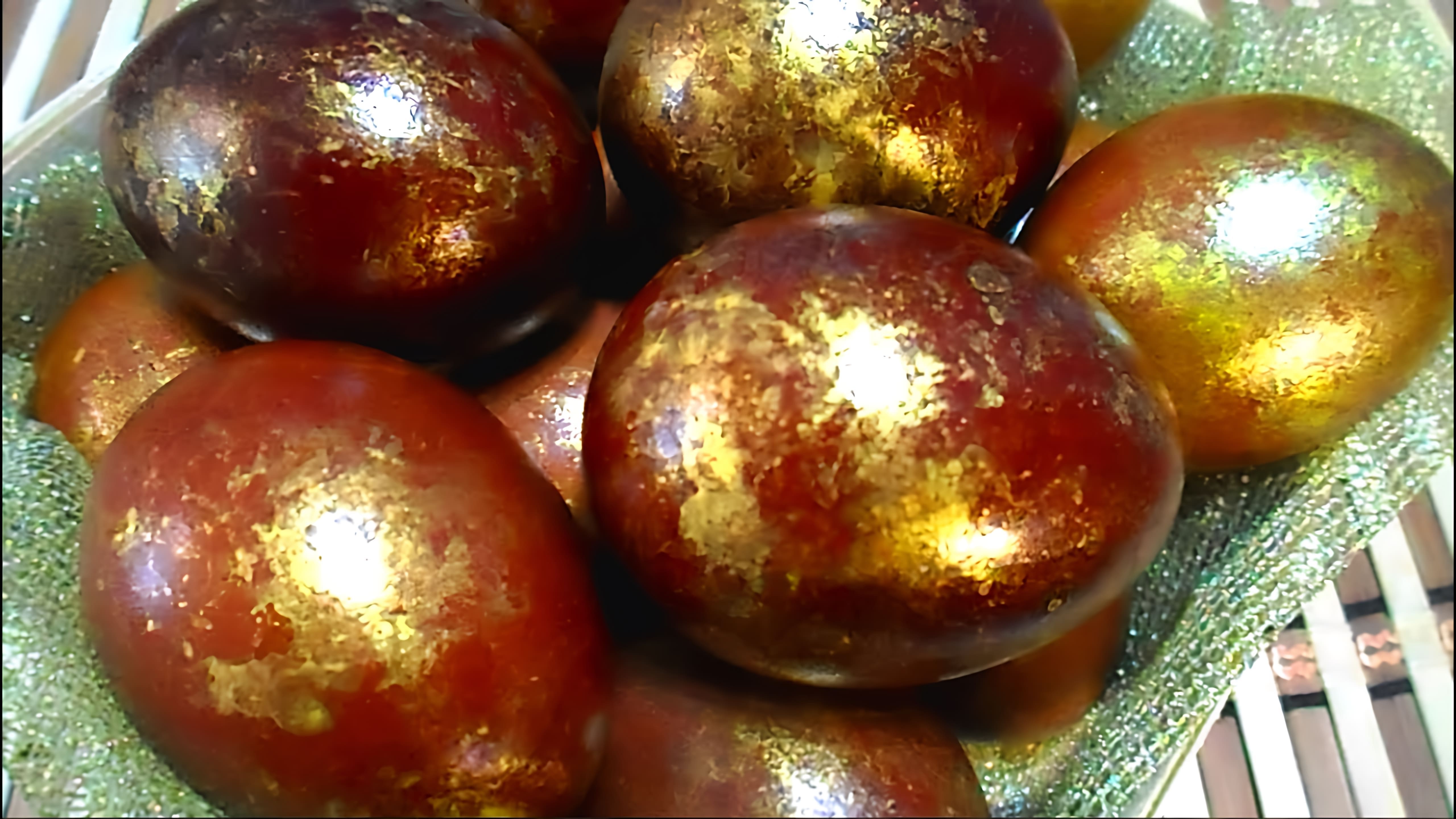В этом видео демонстрируется процесс окрашивания яиц на Пасху в луковой шелухе с использованием желатинового красителя для получения золотистого эффекта