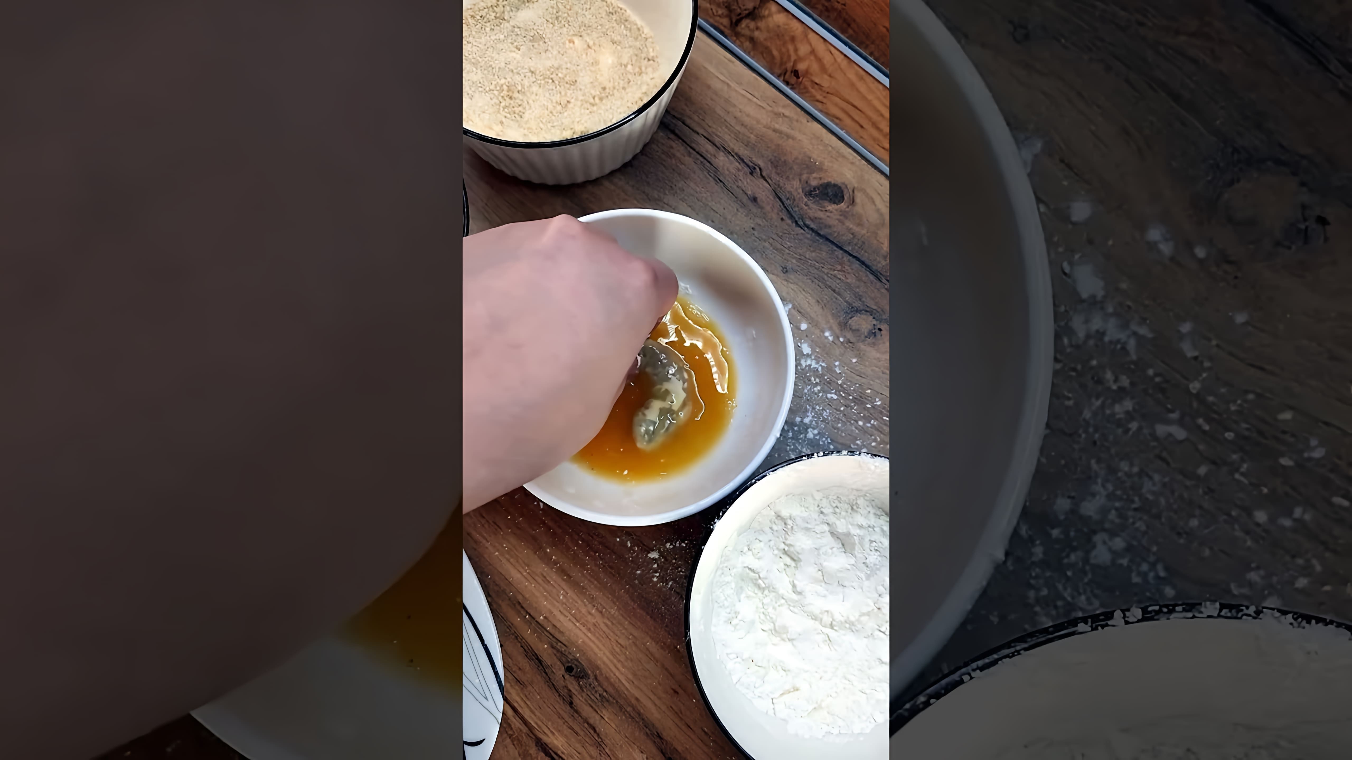 В этом видео демонстрируется процесс приготовления креветок в кляре