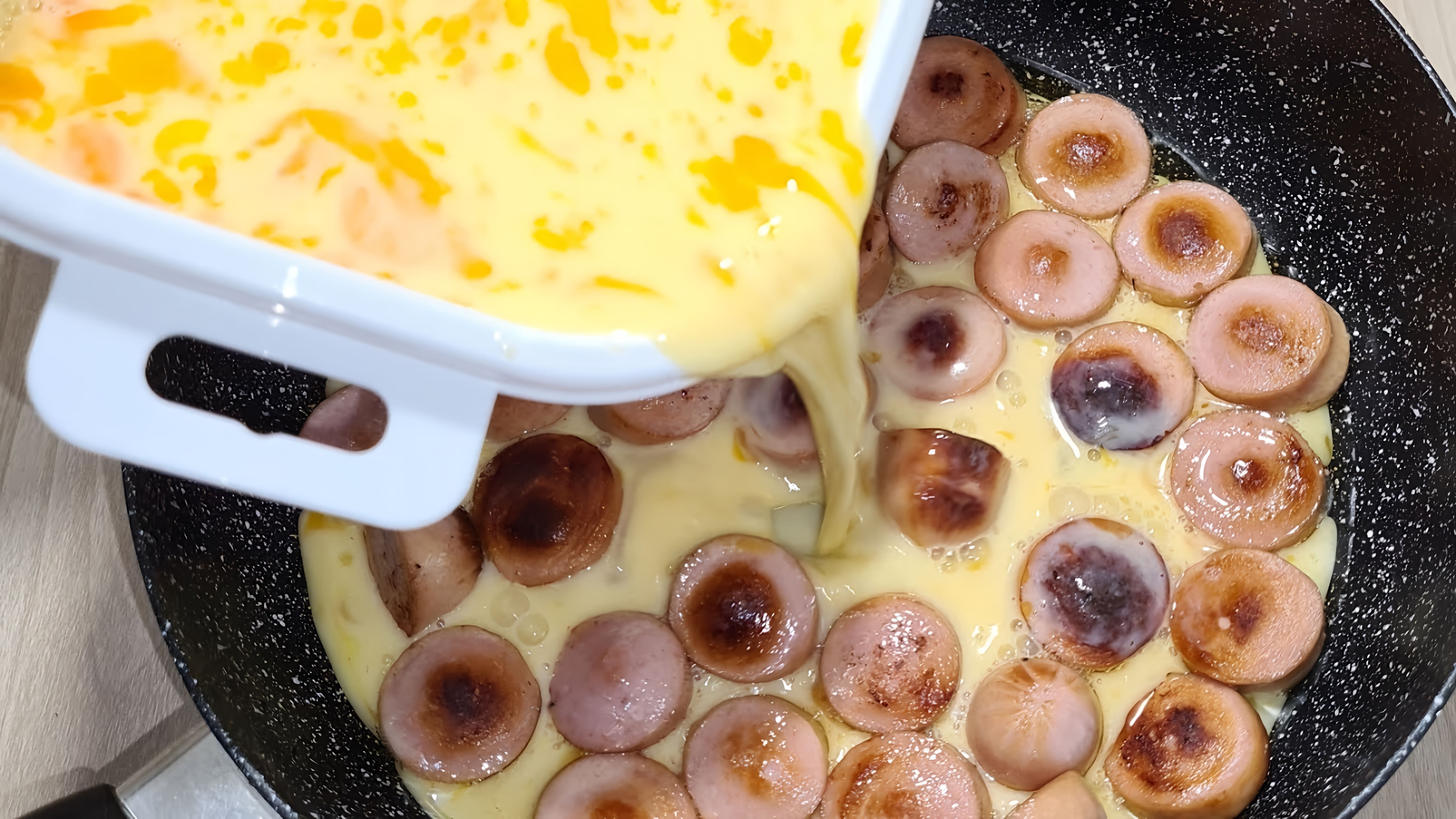 В этом видео демонстрируется простой и быстрый рецепт приготовления омлета с сосисками и сыром