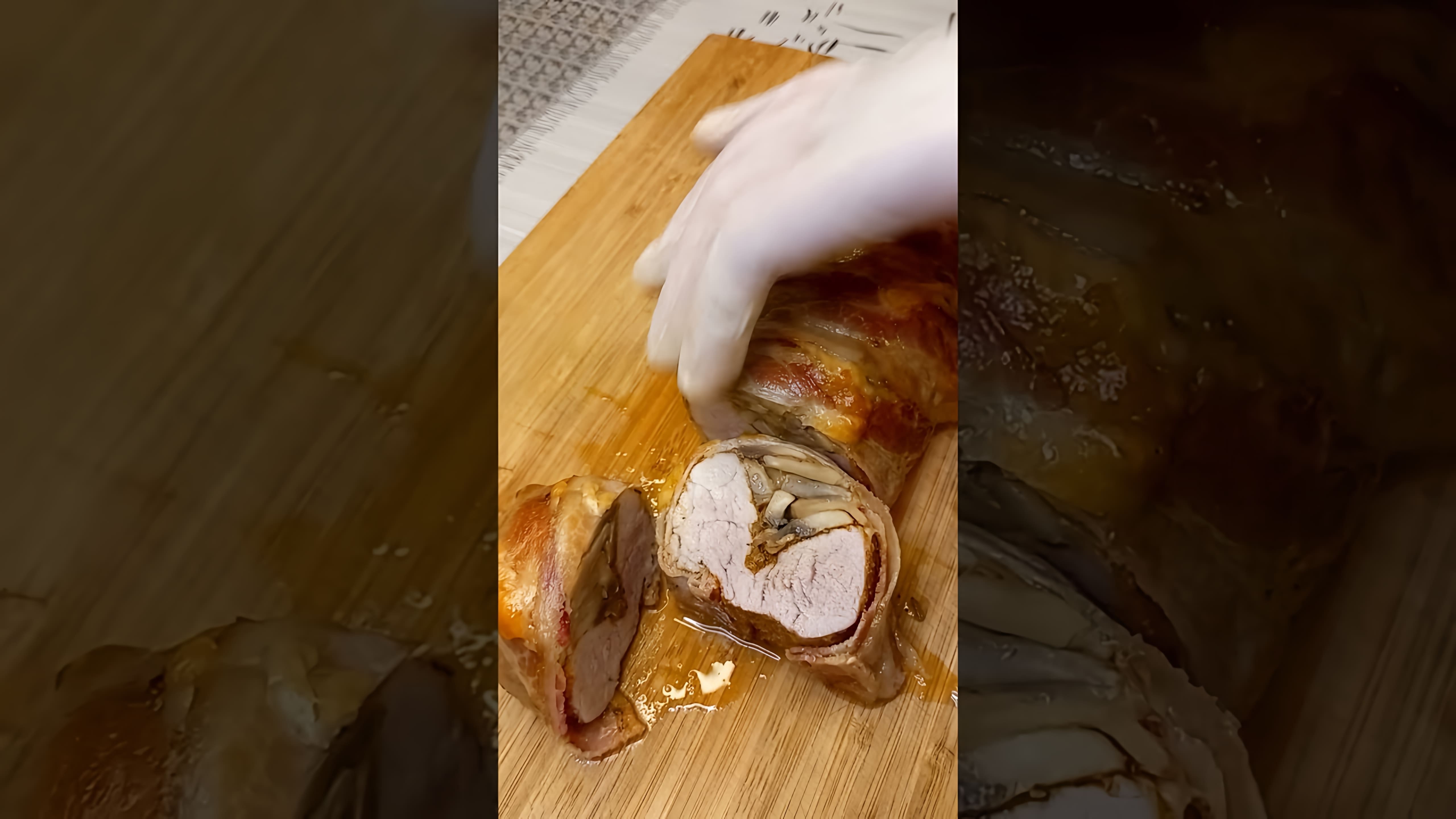 В этом видео демонстрируется процесс приготовления запеченной свиной вырезки с грибами и сыром для новогоднего стола