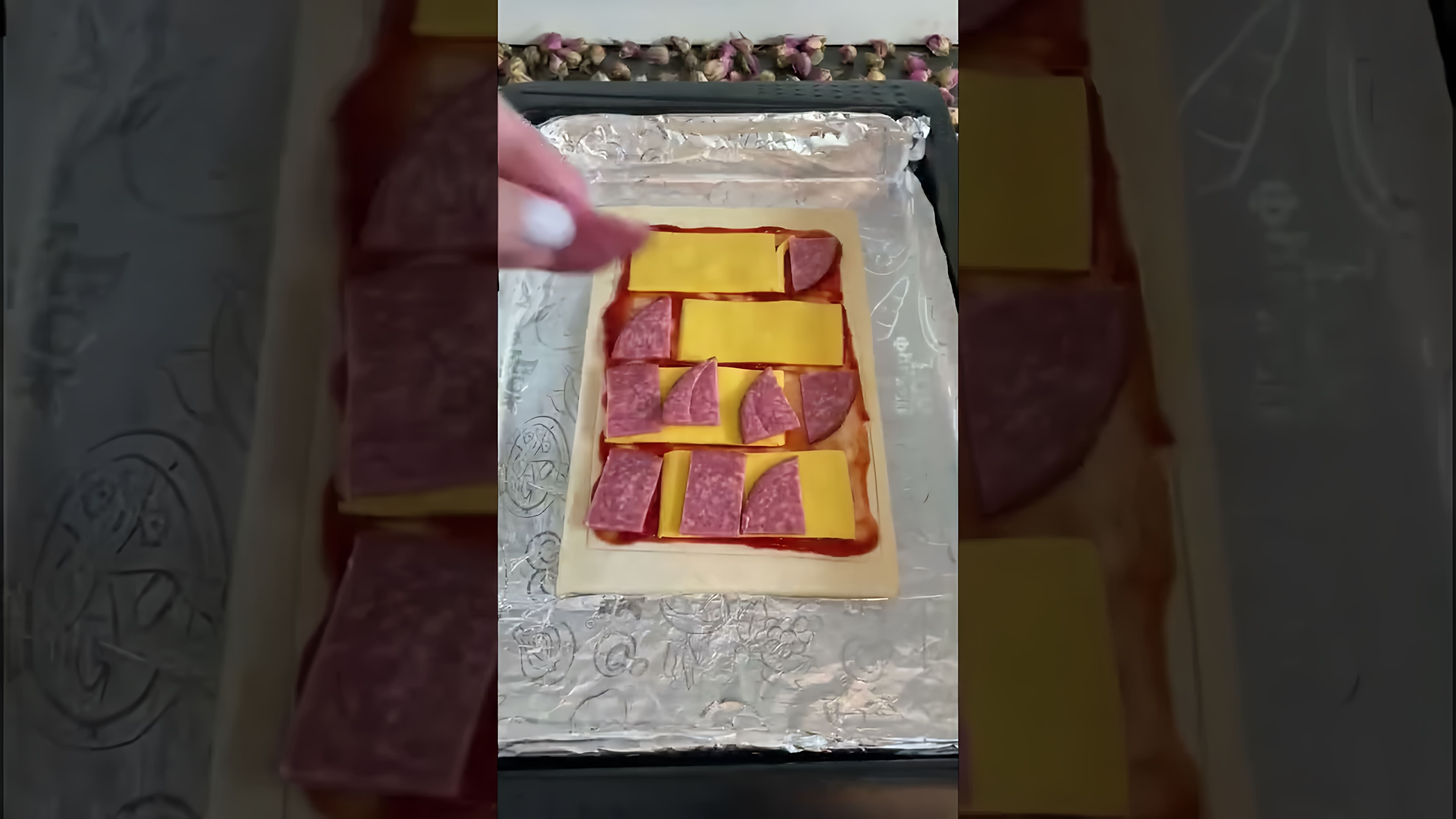 В этом видео демонстрируется процесс приготовления пиццы по-быстрому из слоеного теста