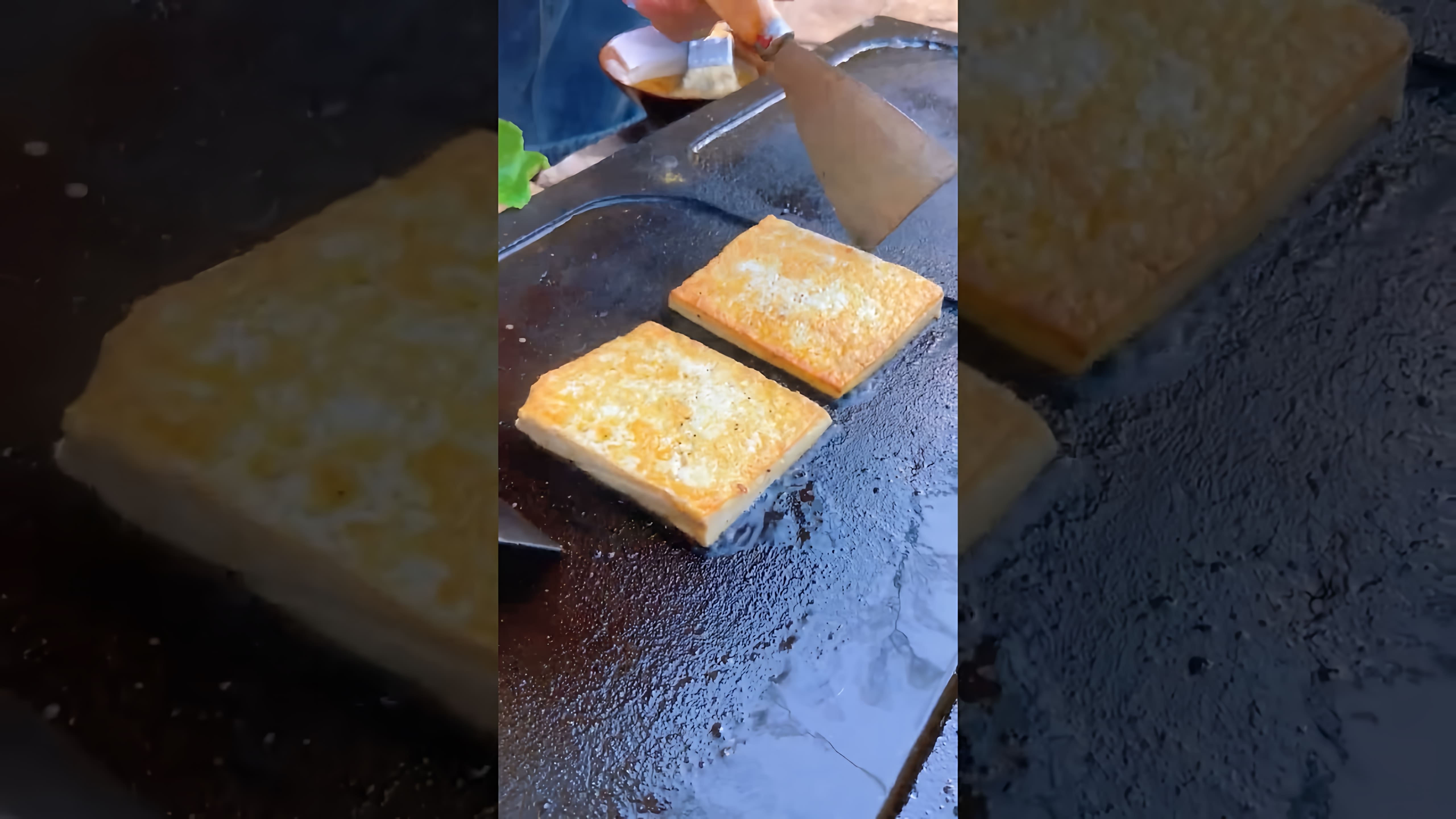 В данном видео-ролике демонстрируется процесс приготовления китайского бургера с использованием жареных кубиков тофу