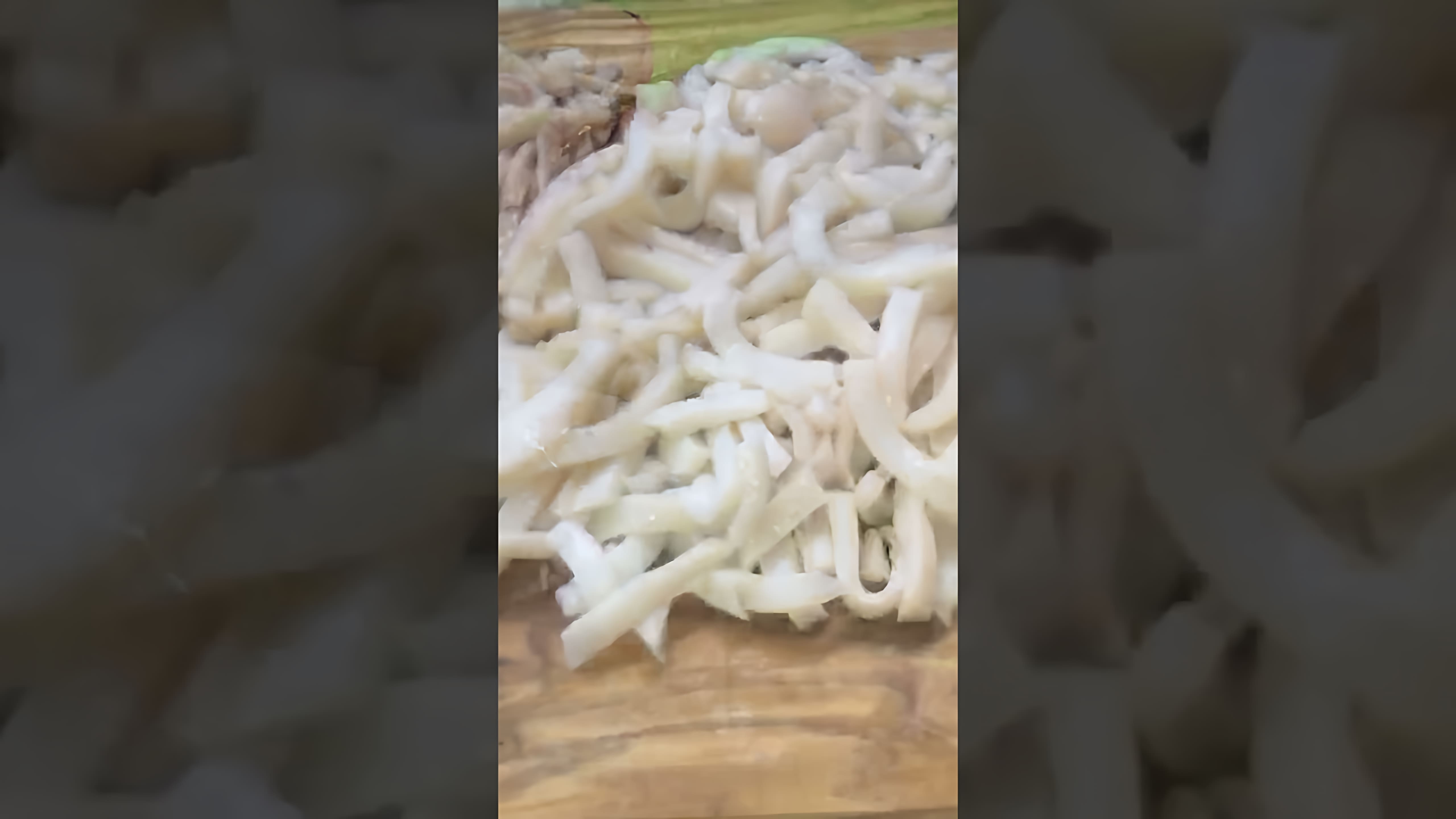 В этом видео демонстрируется процесс приготовления вкусного салата с кальмарами