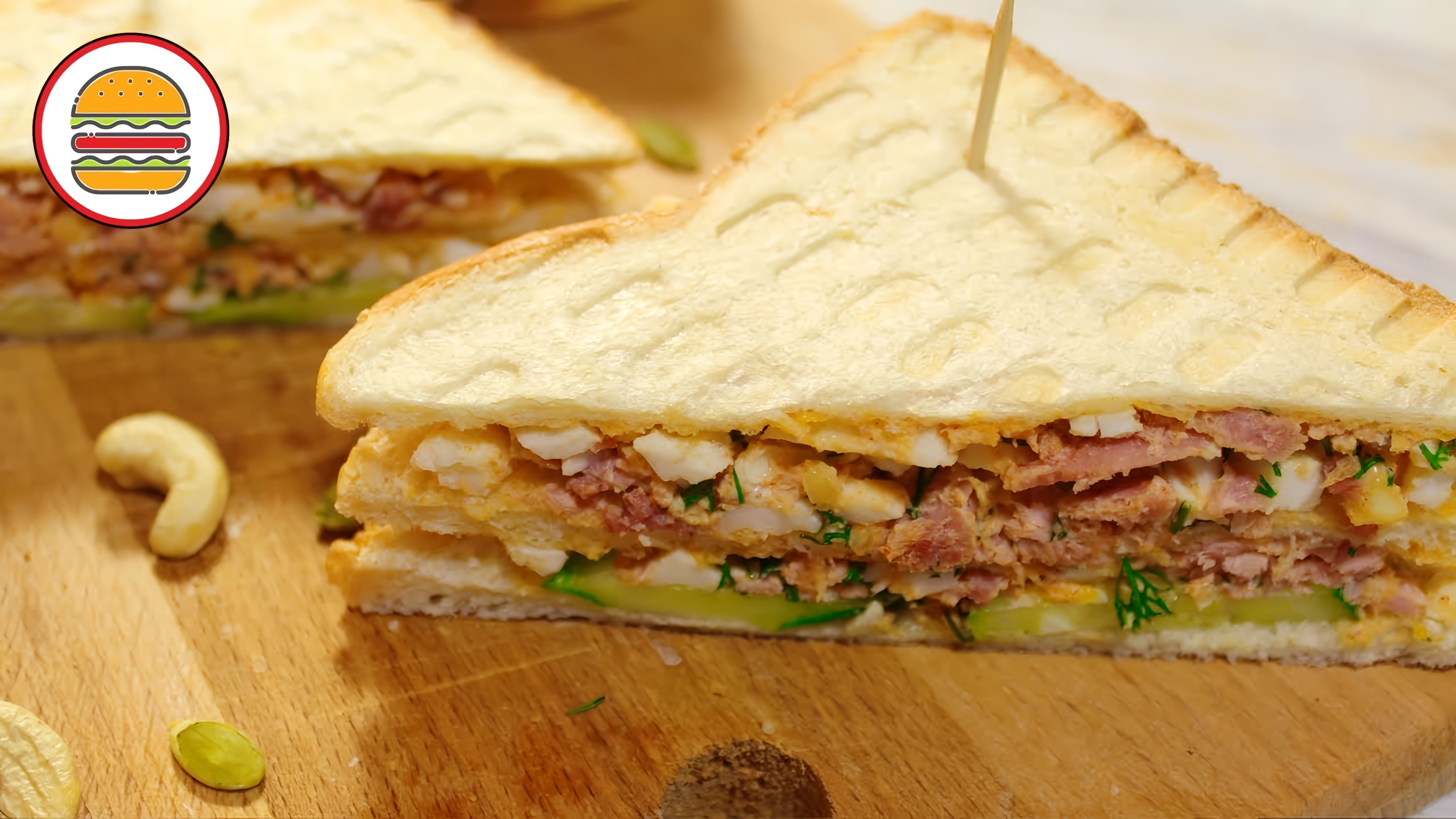 Клаб-сэндвич с тунцом - это вкусный бутерброд, который состоит из двух ломтиков белого хлеба, на которых расположены кусочки тунца, яйца и орешки