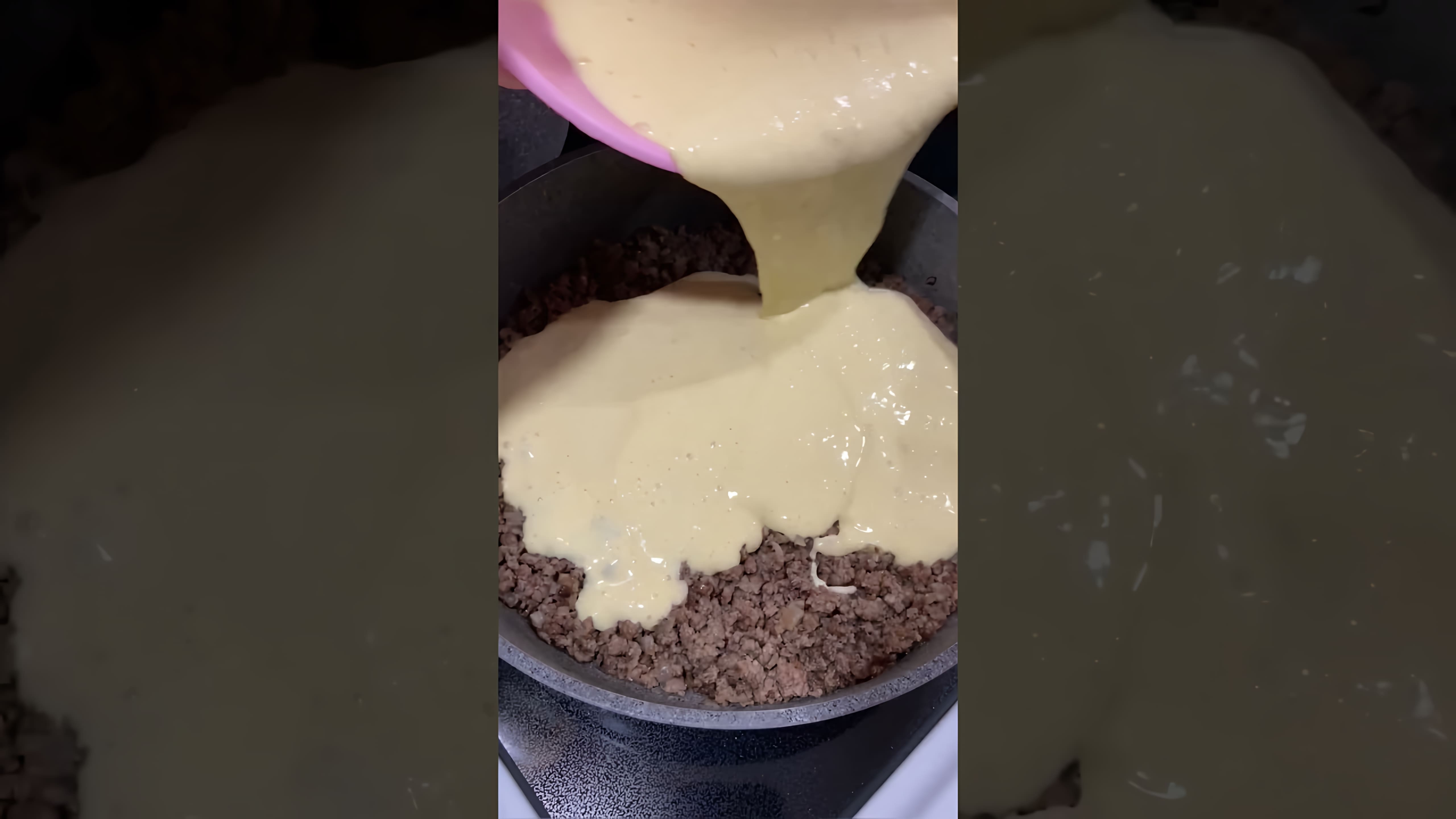 В этом видео демонстрируется процесс приготовления мясного пирога на сковородке