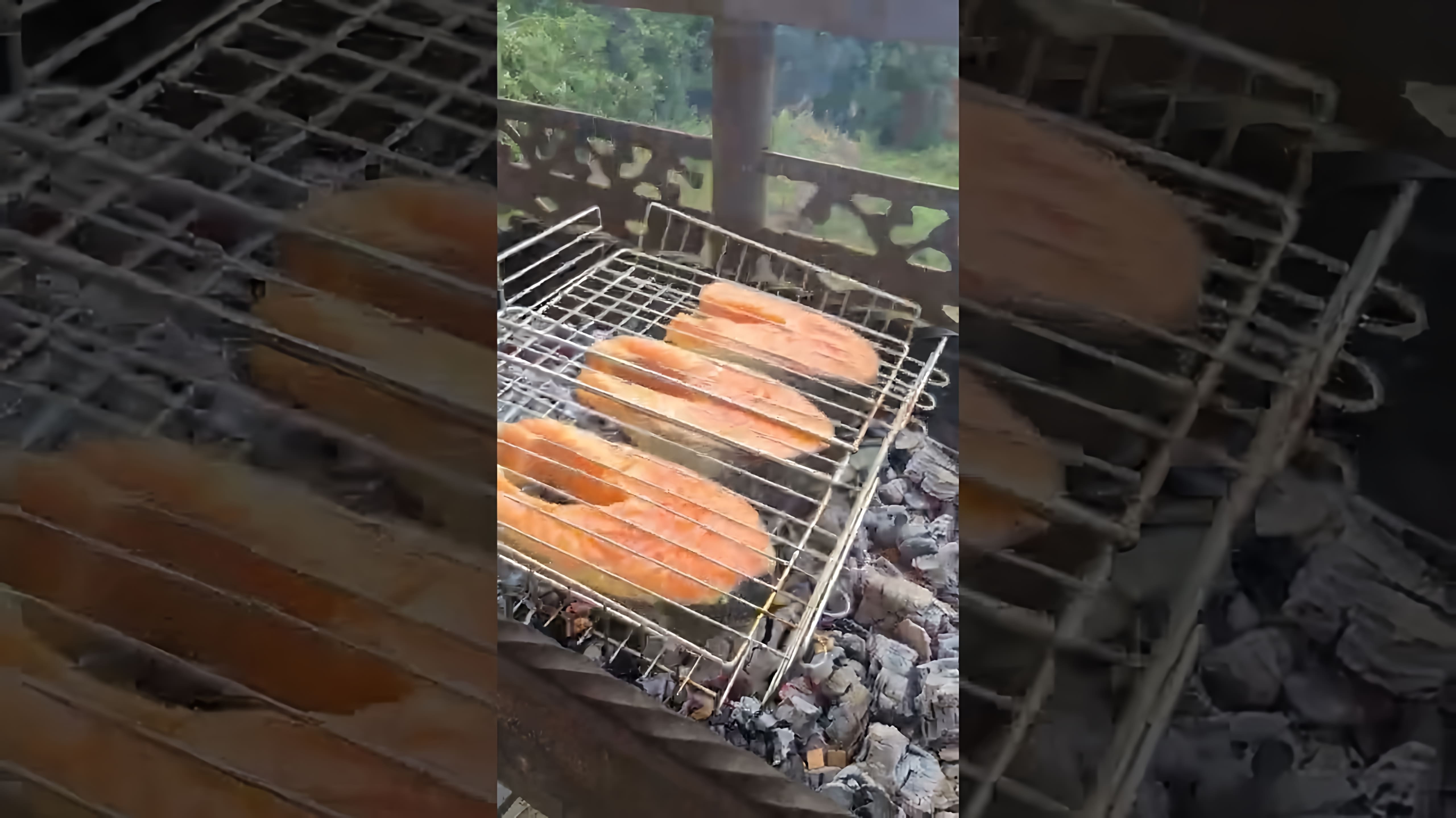 В этом видео демонстрируется процесс приготовления ароматных стейков из сёмги на углях