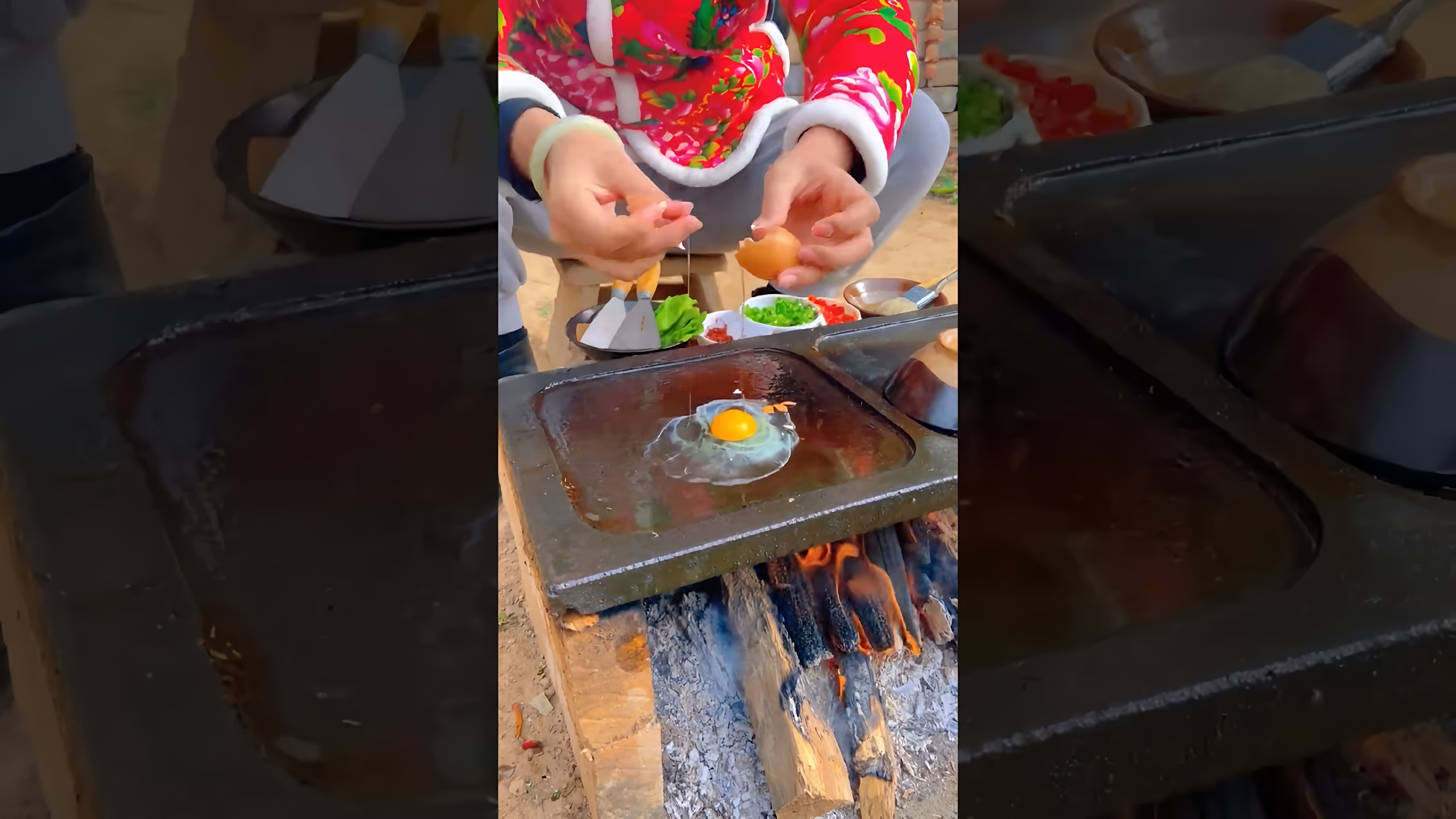 В этом видео-ролике демонстрируется процесс приготовления китайского бургера с жареными яйцами и салатом