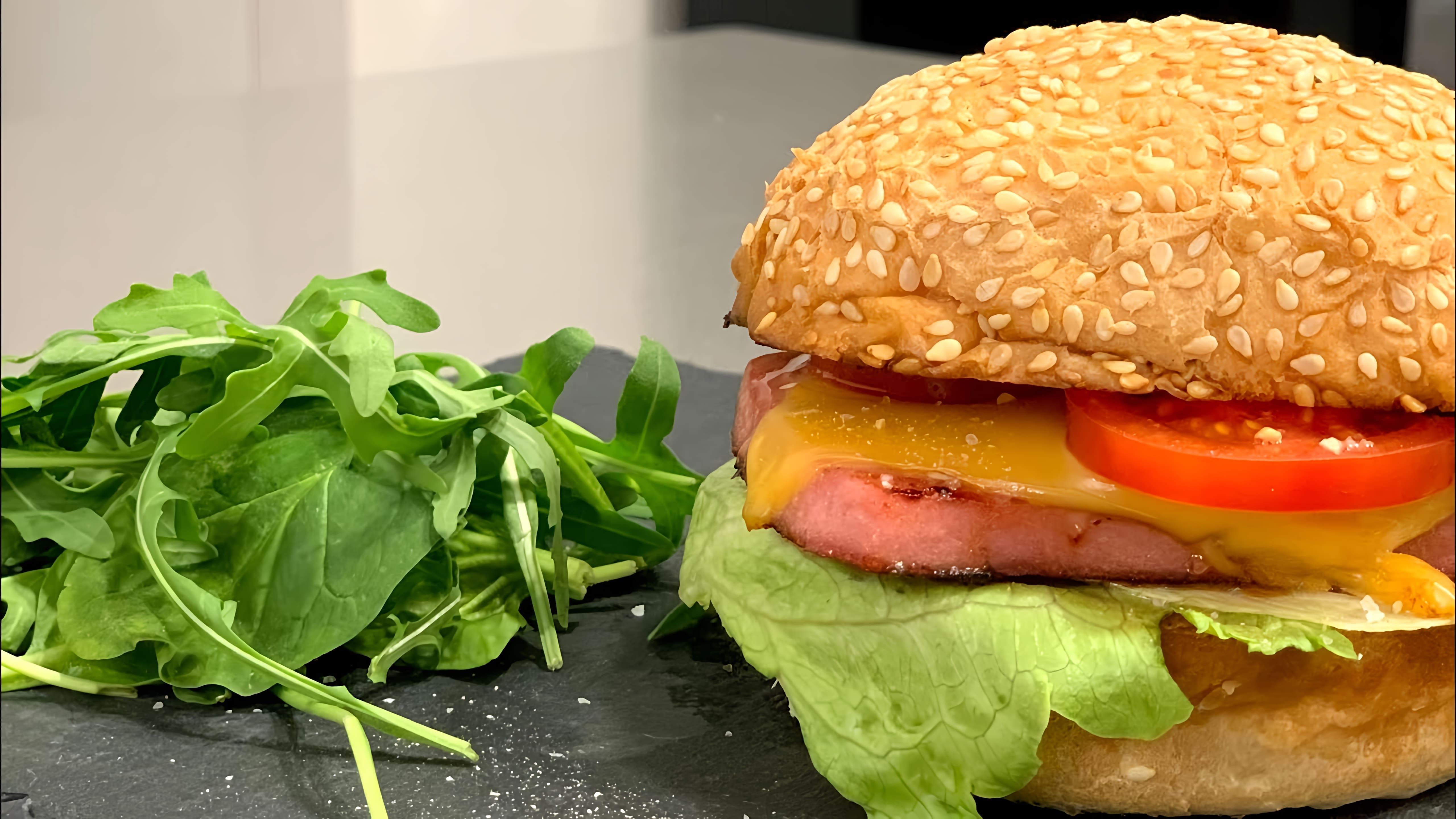 В этом видео демонстрируется процесс приготовления домашнего гамбургера с колбасой, сыром, помидором и салатом Айсберг