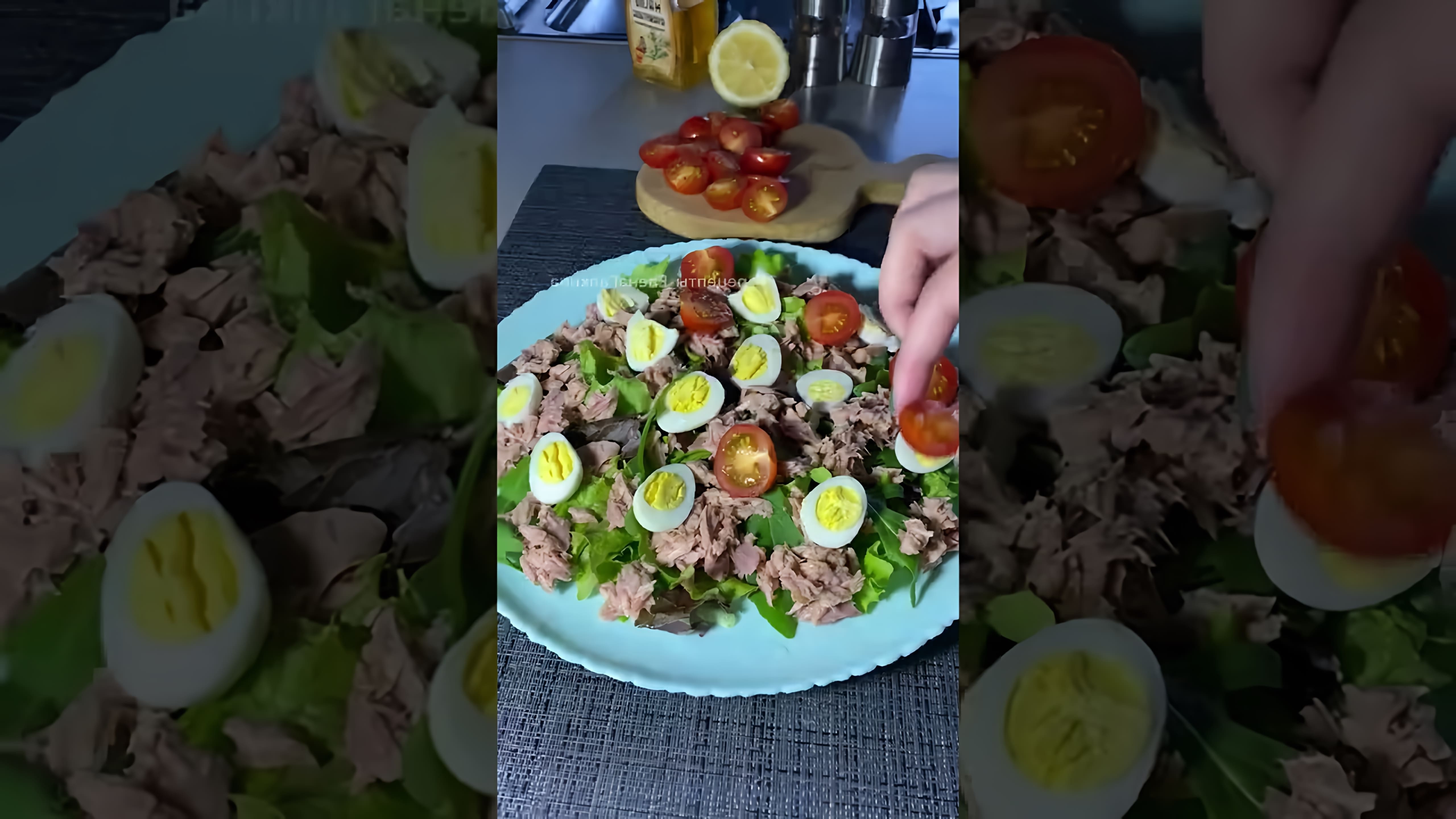 В этом видео демонстрируется процесс приготовления салата с консервированным тунцом, черри и перепелиными яйцами