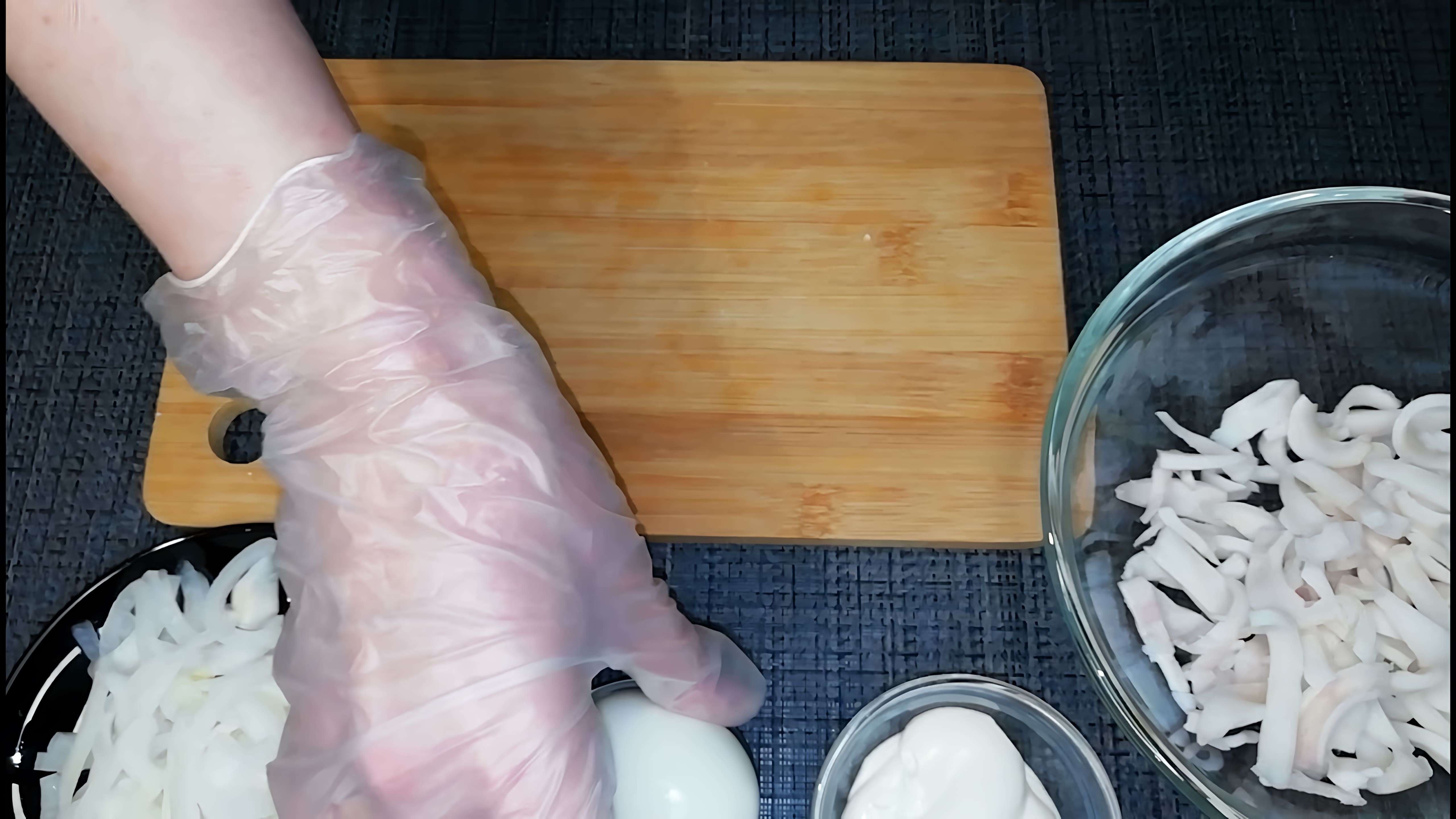 В этом видео демонстрируется процесс приготовления салата из кальмаров и маринованного лука