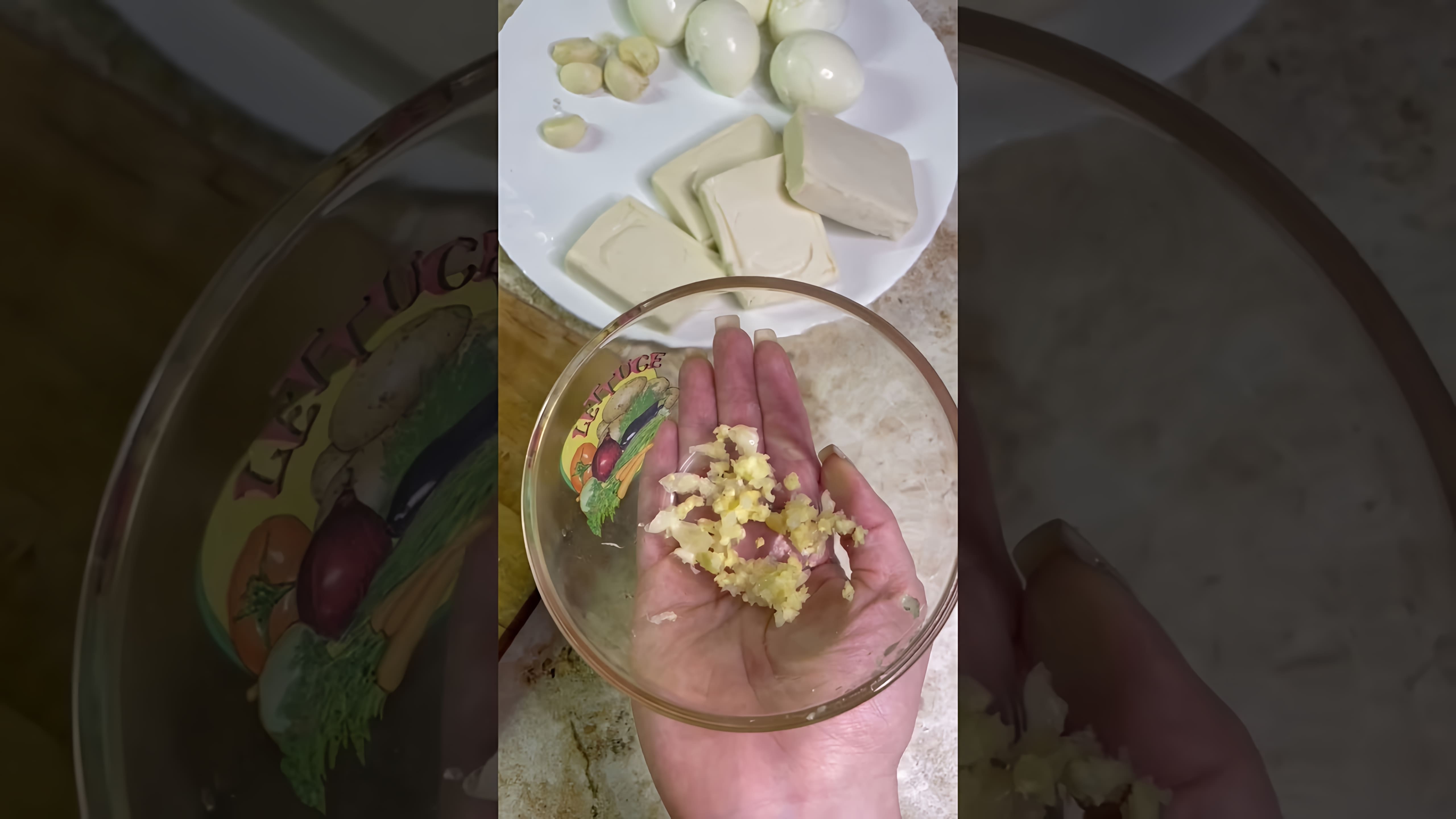 В этом видео демонстрируется процесс приготовления бюджетной закуски из плавленых сырков, яиц, чеснока и майонеза