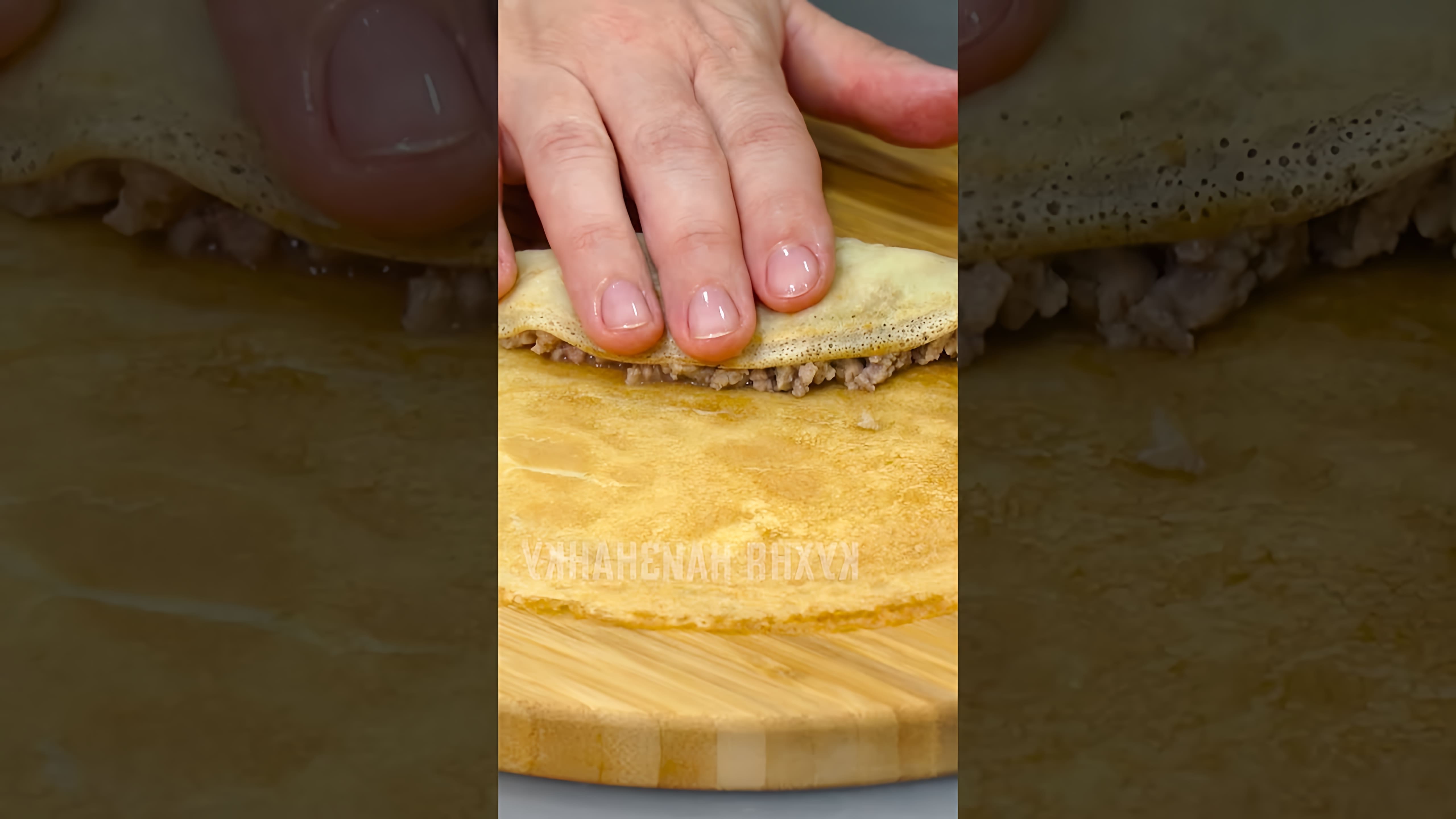 В этом видео демонстрируется процесс приготовления блинчиков с мясной начинкой